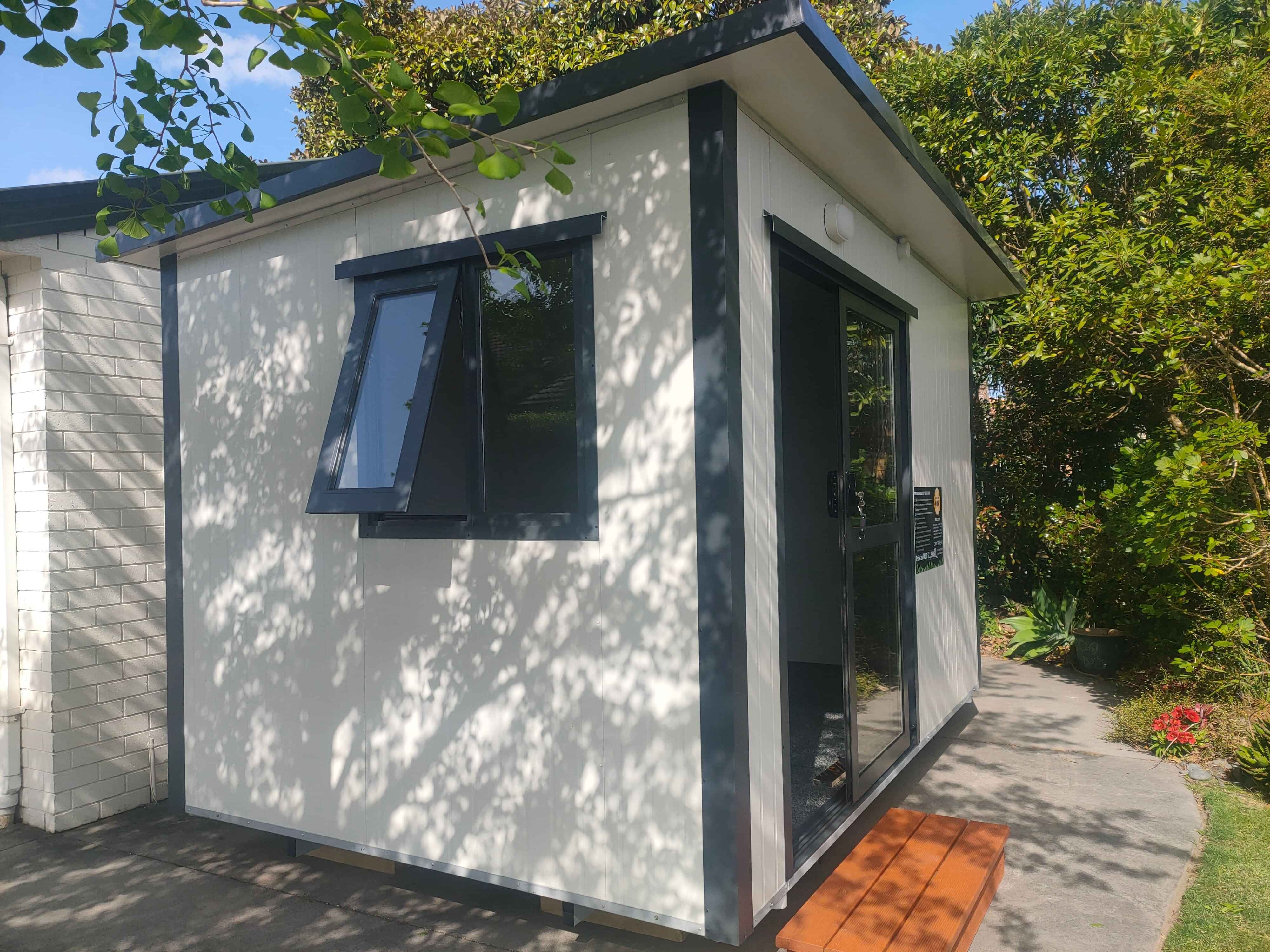 3.6m x 2.4m black cabin with two windows and entrance step