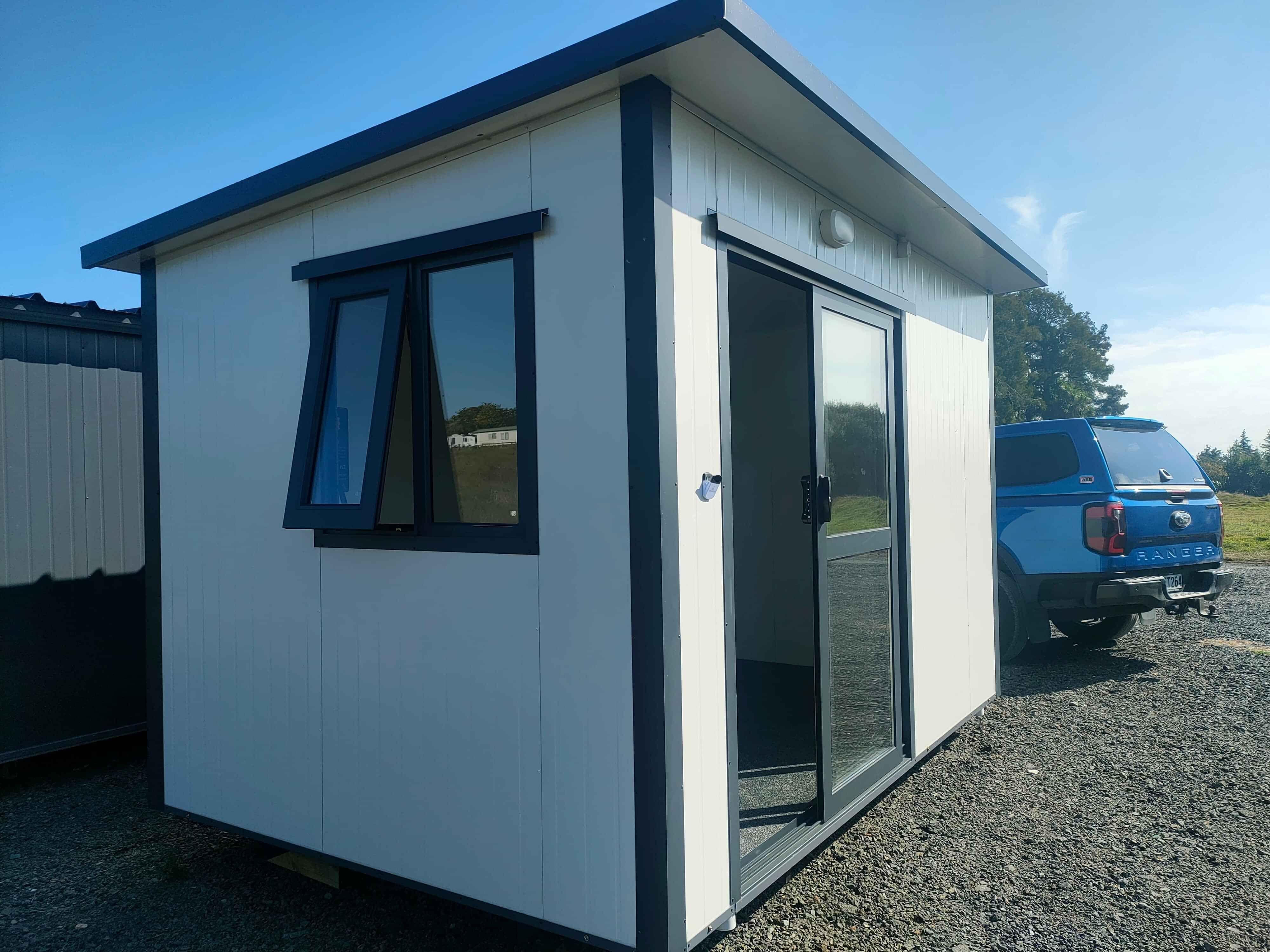 3.6m x 2.4m black cabin with two windows and entrance step