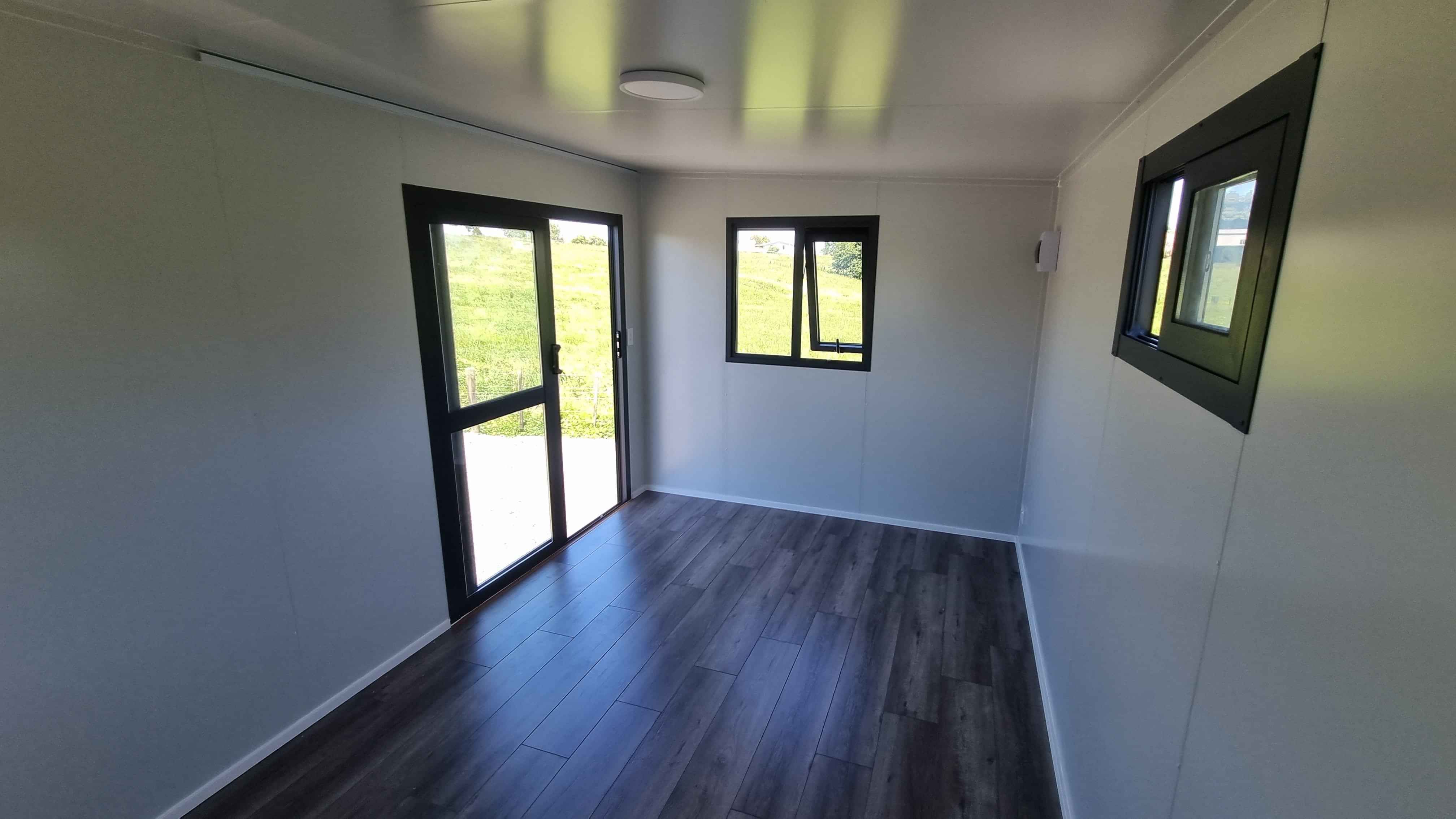 4.6m x 2.7m grey cabin with high window on the back wall