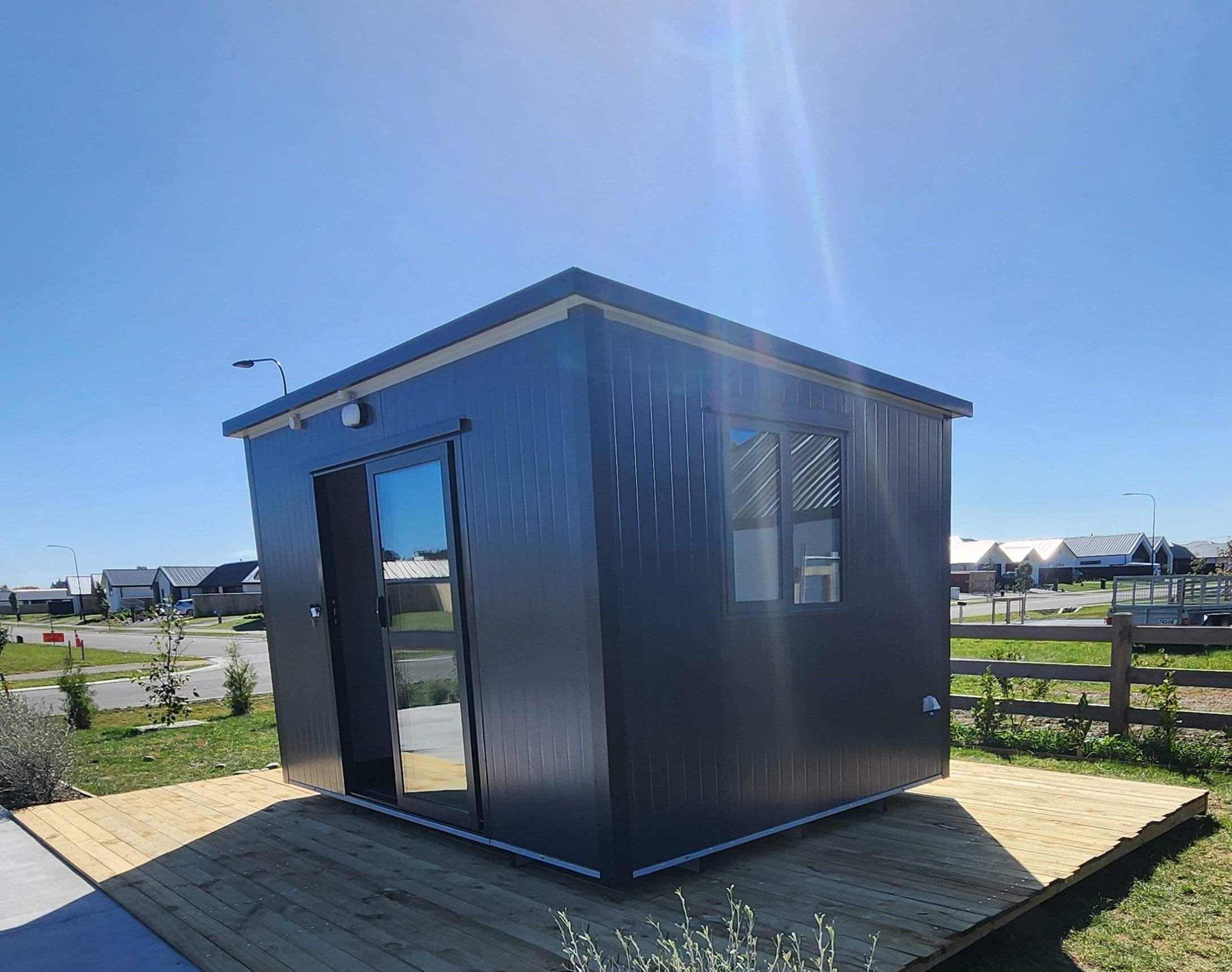 3.6m x 2.4m black cabin with two windows and entrance step