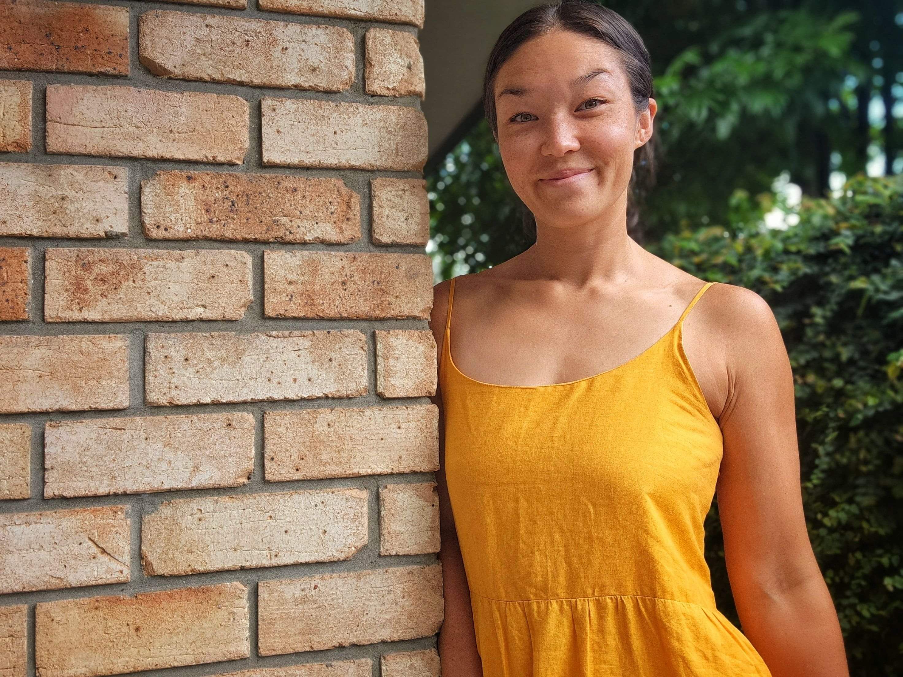 Business owner standing next to brick wall