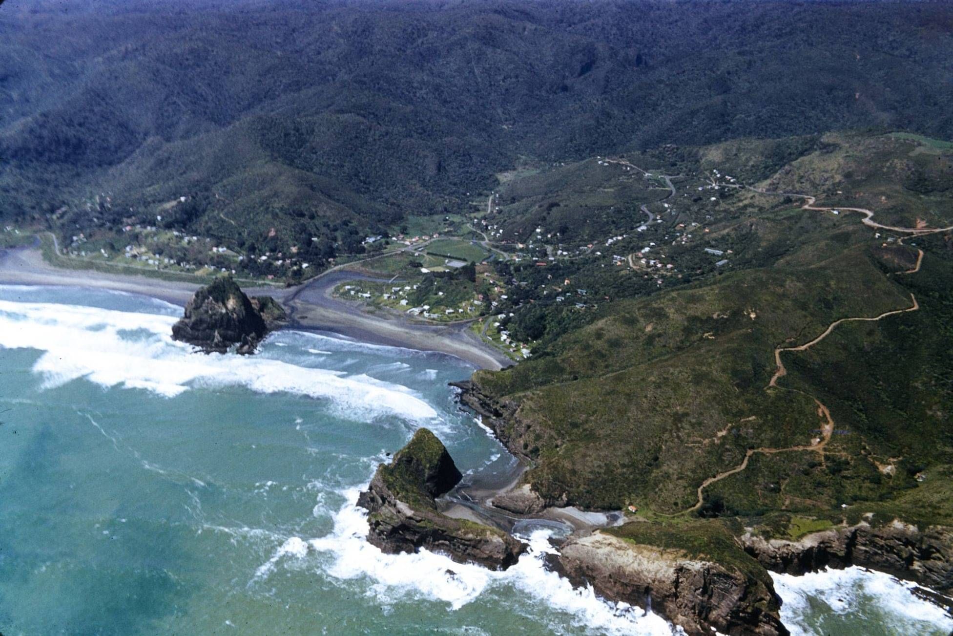 Aerial view of the southern end of Piha showing Taitomo Island and Nun Rock in the foreground and Lion Rock.