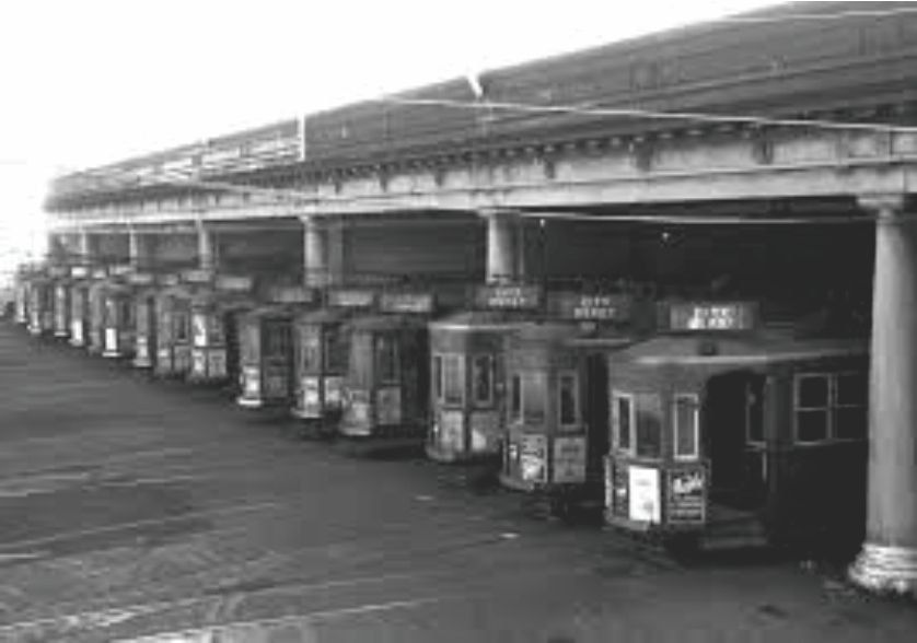 Parked trams all lined up in a shed