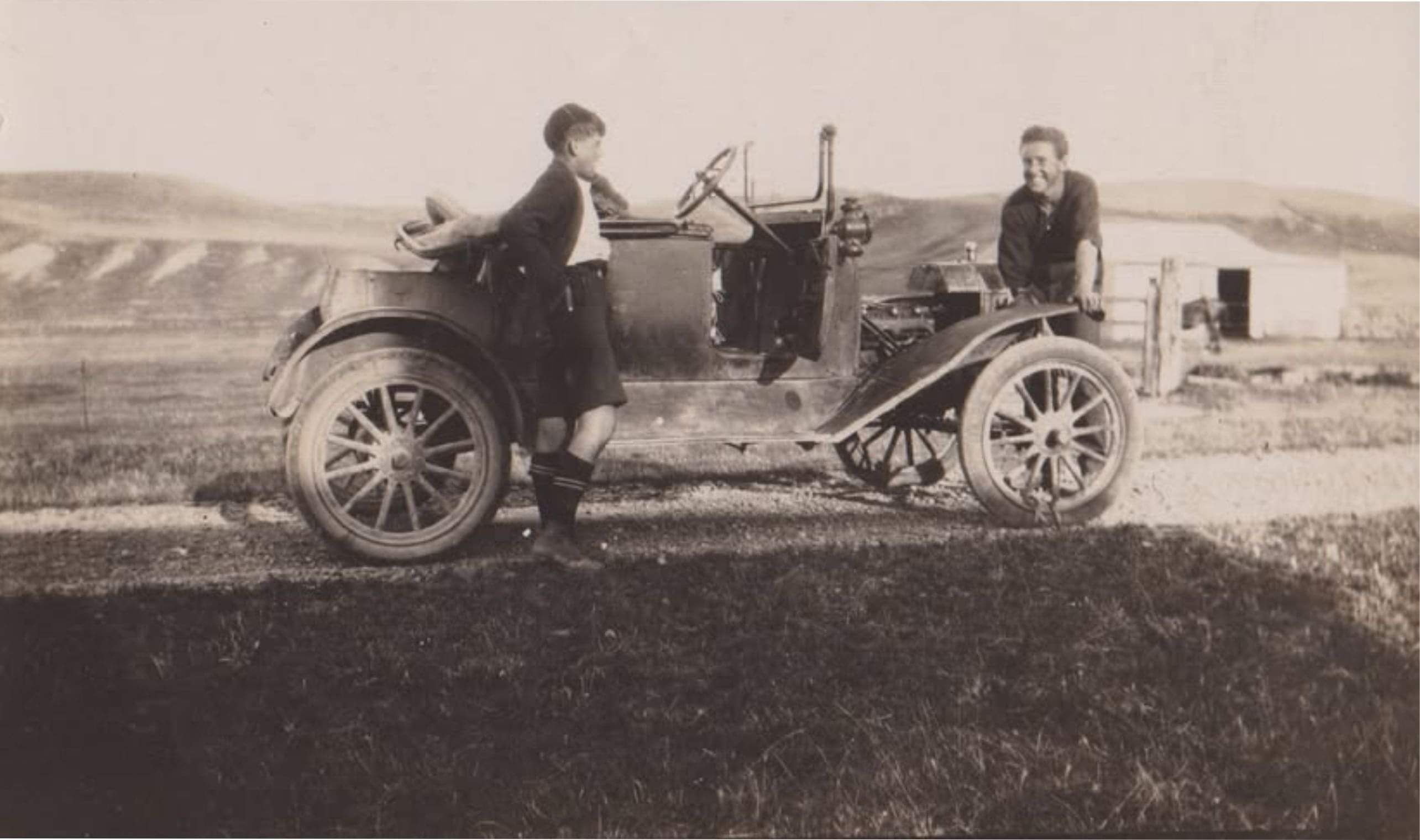 Two men admiring an old motor car