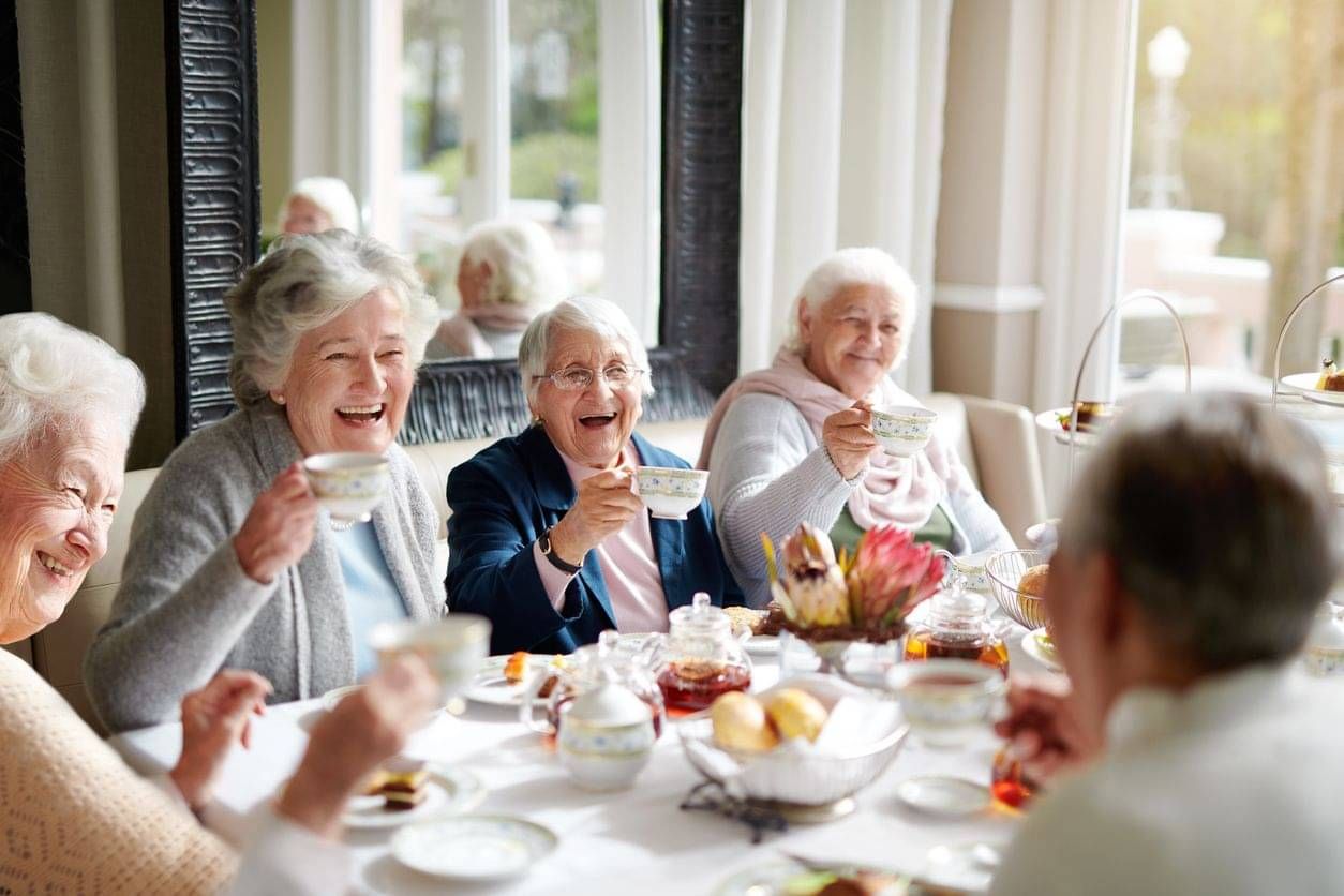 Happy older adults enjoying afternoon tea together