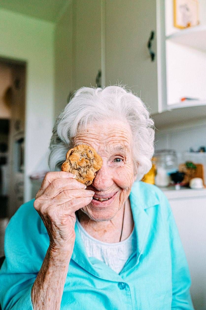 Happy older person using a cookie as an eye patch