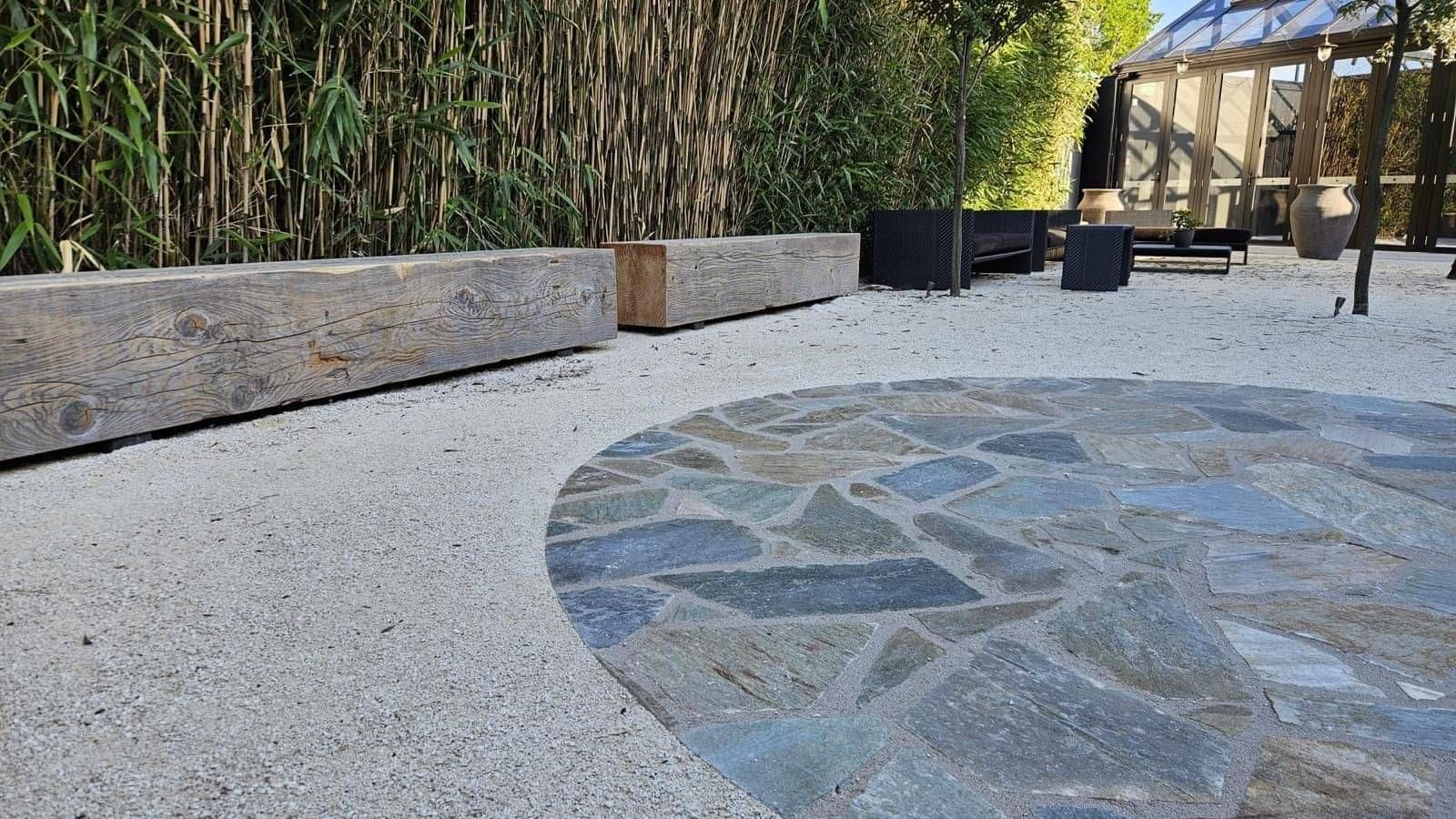 modern outdoor area with fine sand and custom paving, with an emphasis on natural materials with wooden benches