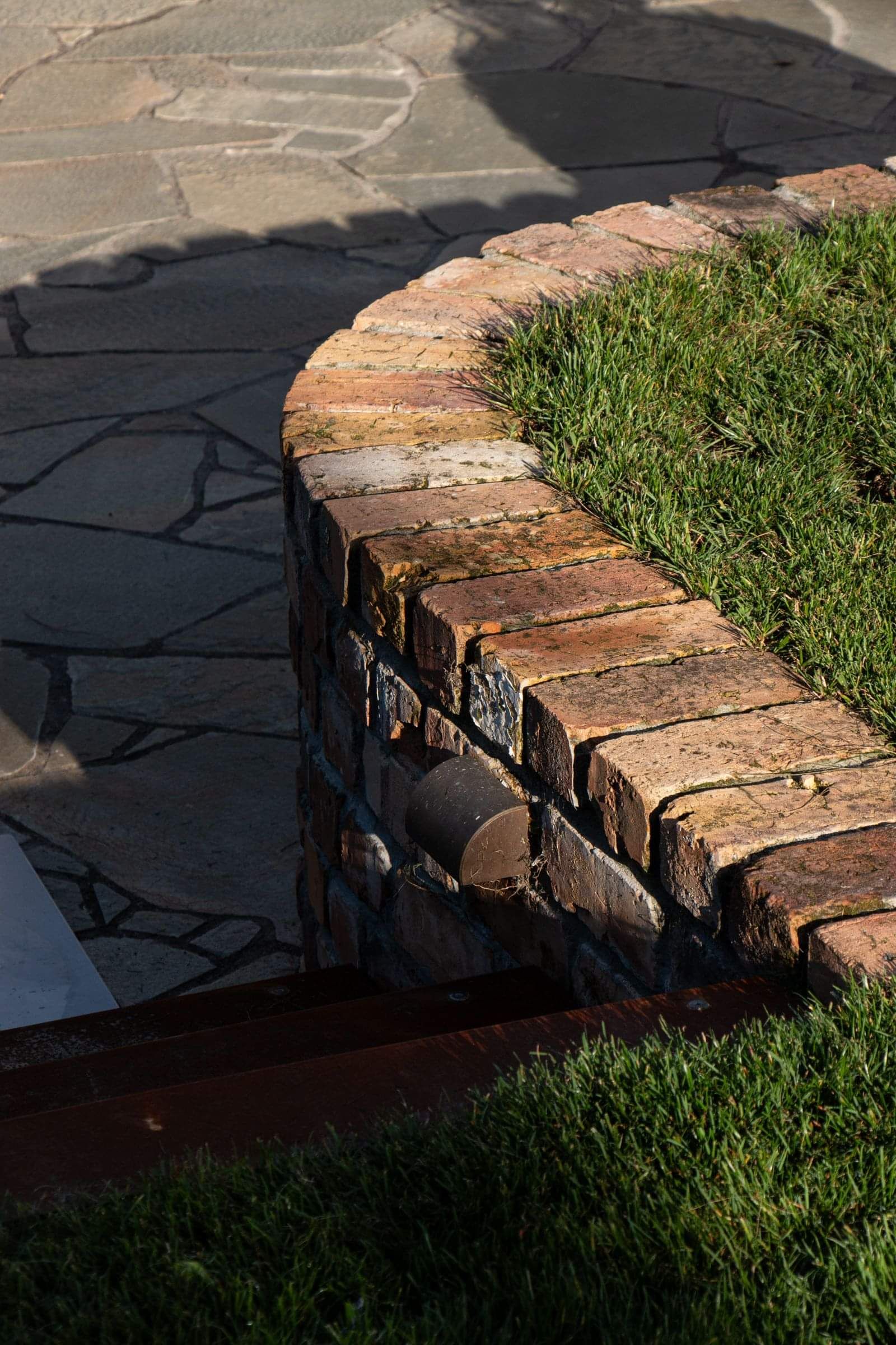 modern outdoor area with fine sand and custom paving, with an emphasis on natural materials with wooden benches