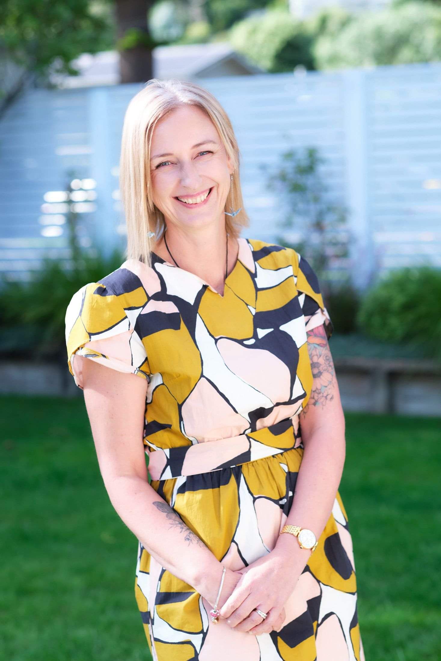 Photo of Gabrielle Ralph from Two Little Birds Consulting standing outside in a summer dress smiling