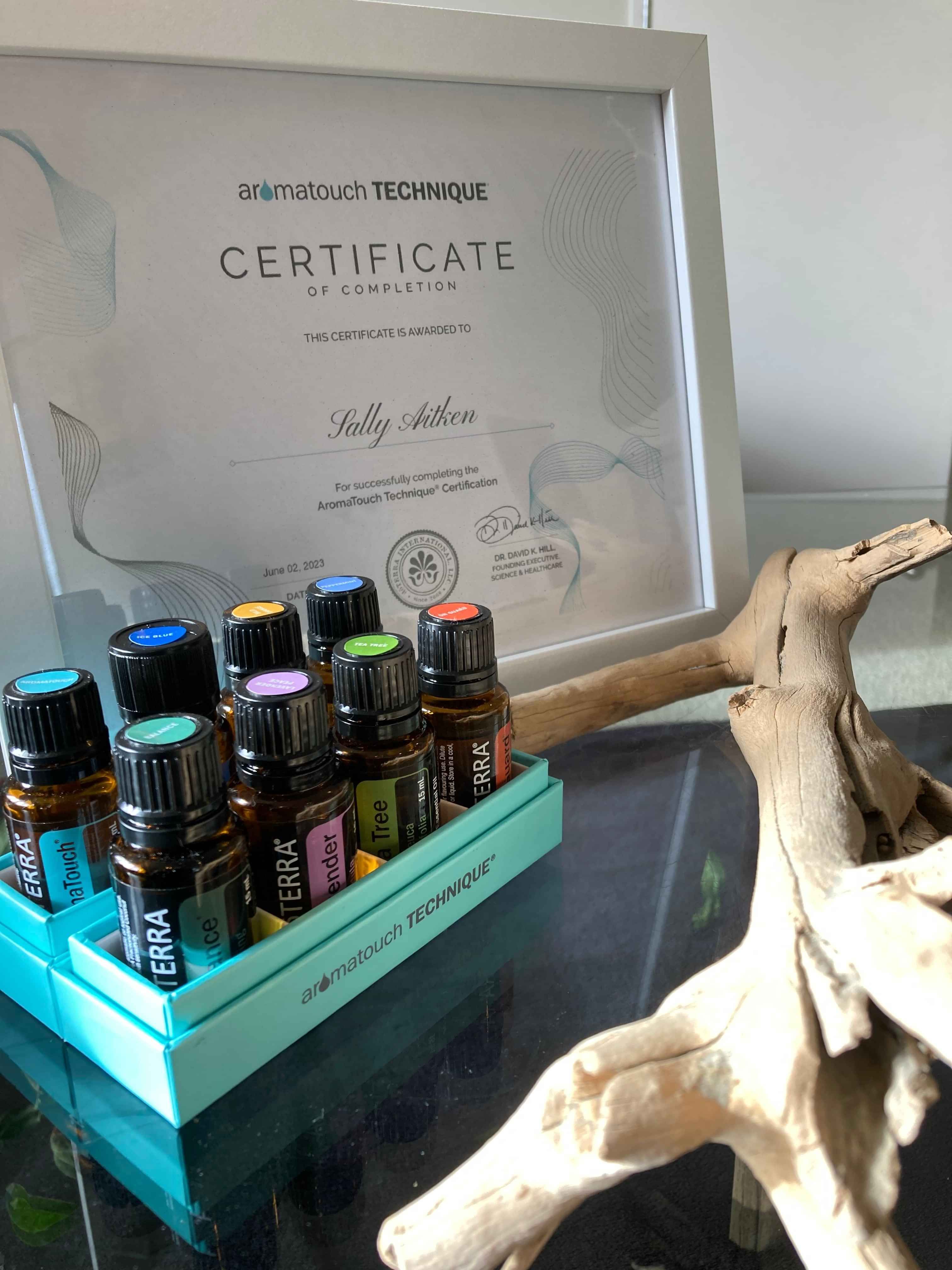 Picture of 8 essential doTERRA essential oils nicely packed in a box on a table with a piece of drift wood in the front