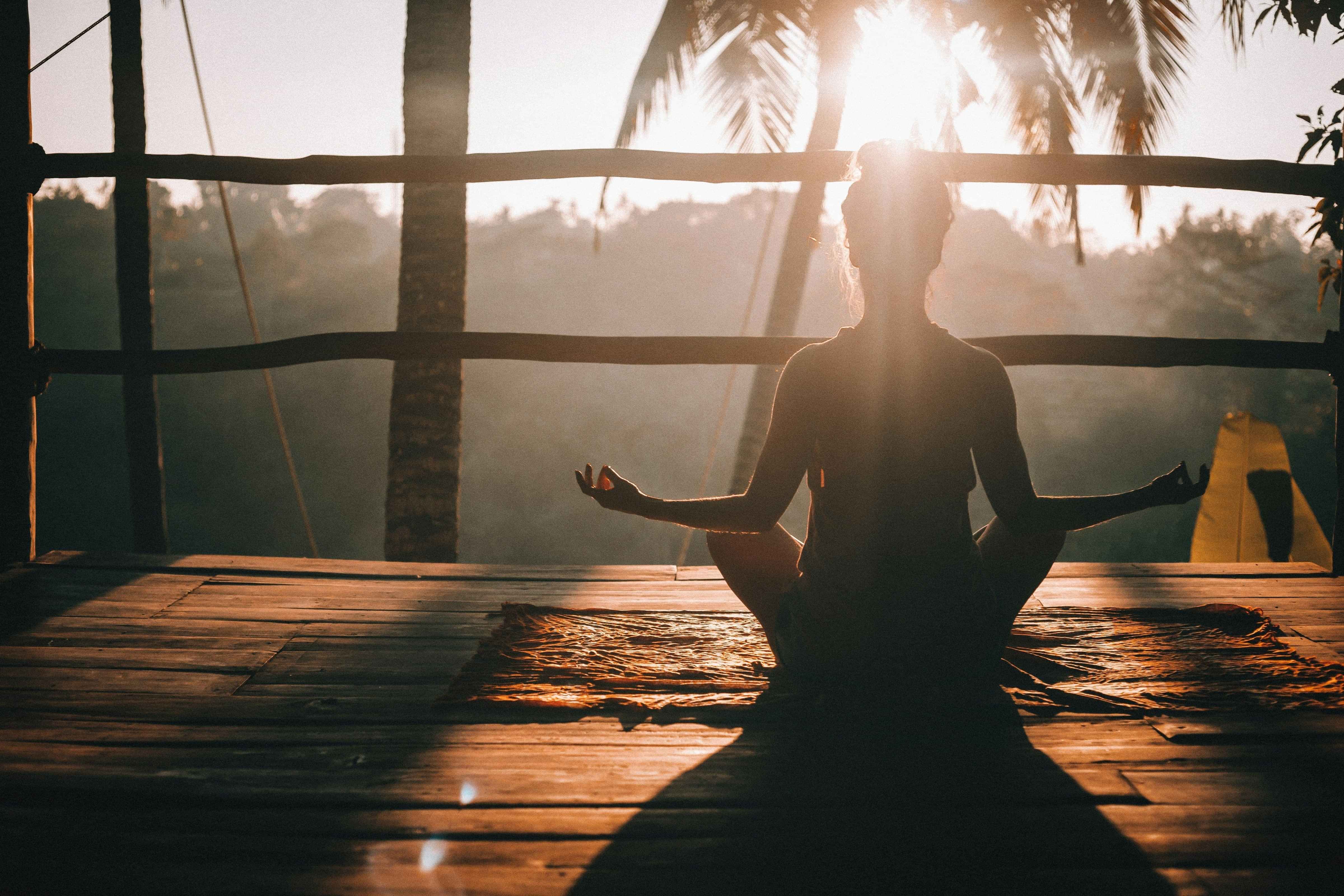 picture of a lady sitting on a deck doing a yoga pose