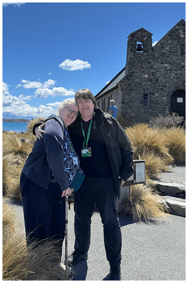 A couple standing outside the Good Shepherd Church in Tekapo, New Zealand.