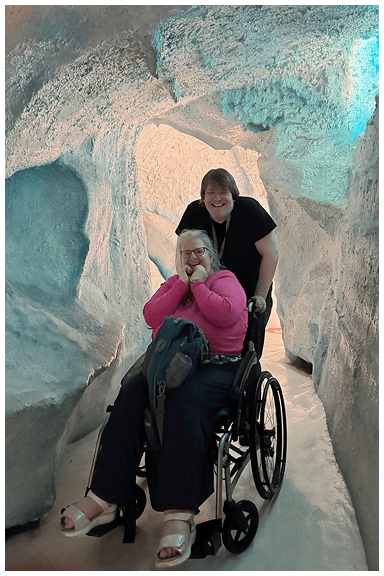 Traveller using manual wheelchair with guide in New Zealand nature setting, enjoying flexible support, in a glacier in the South Island of NZ
