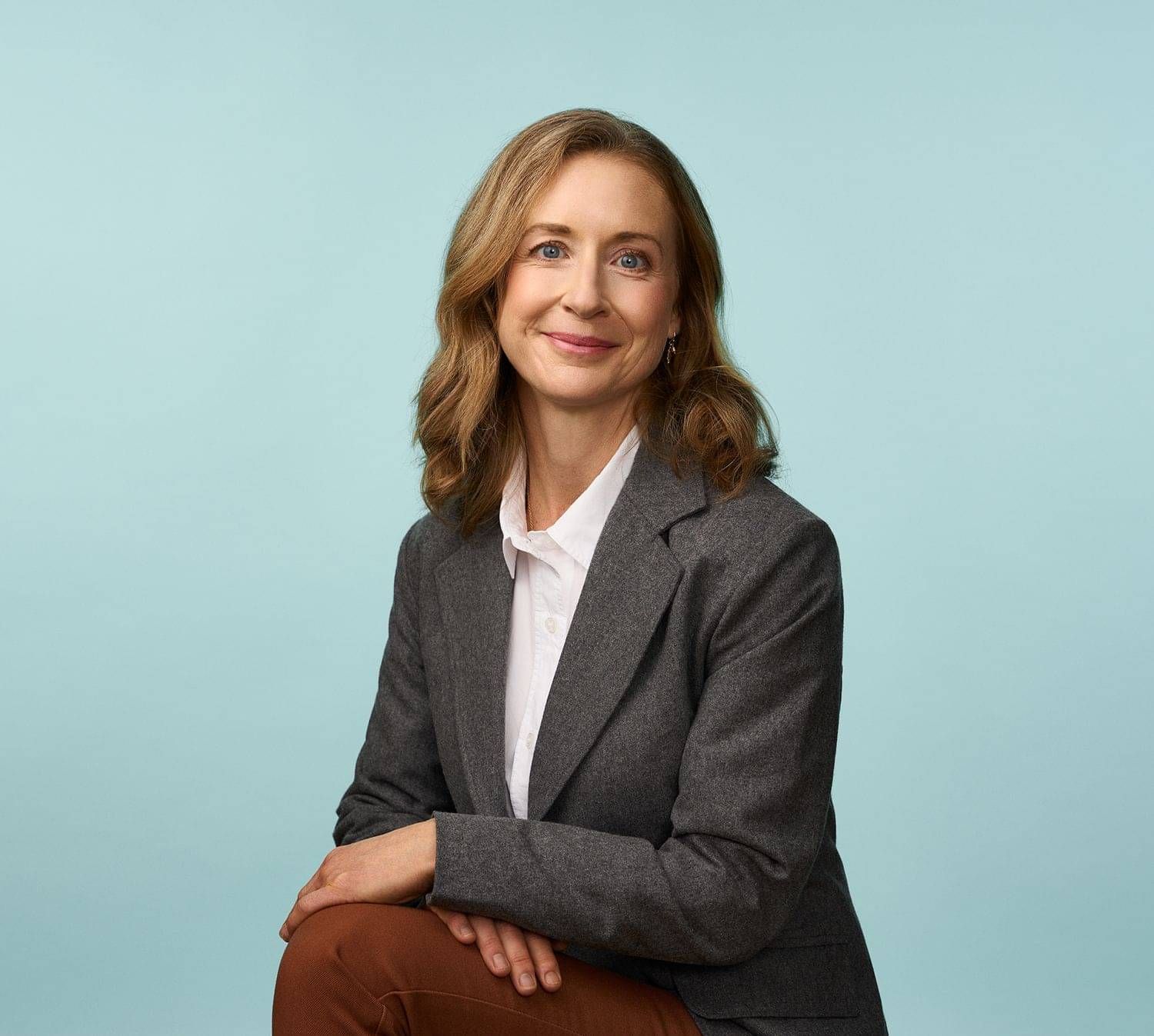 Rachel Opie, public and international law expert, seated side-on in a grey suit jacket