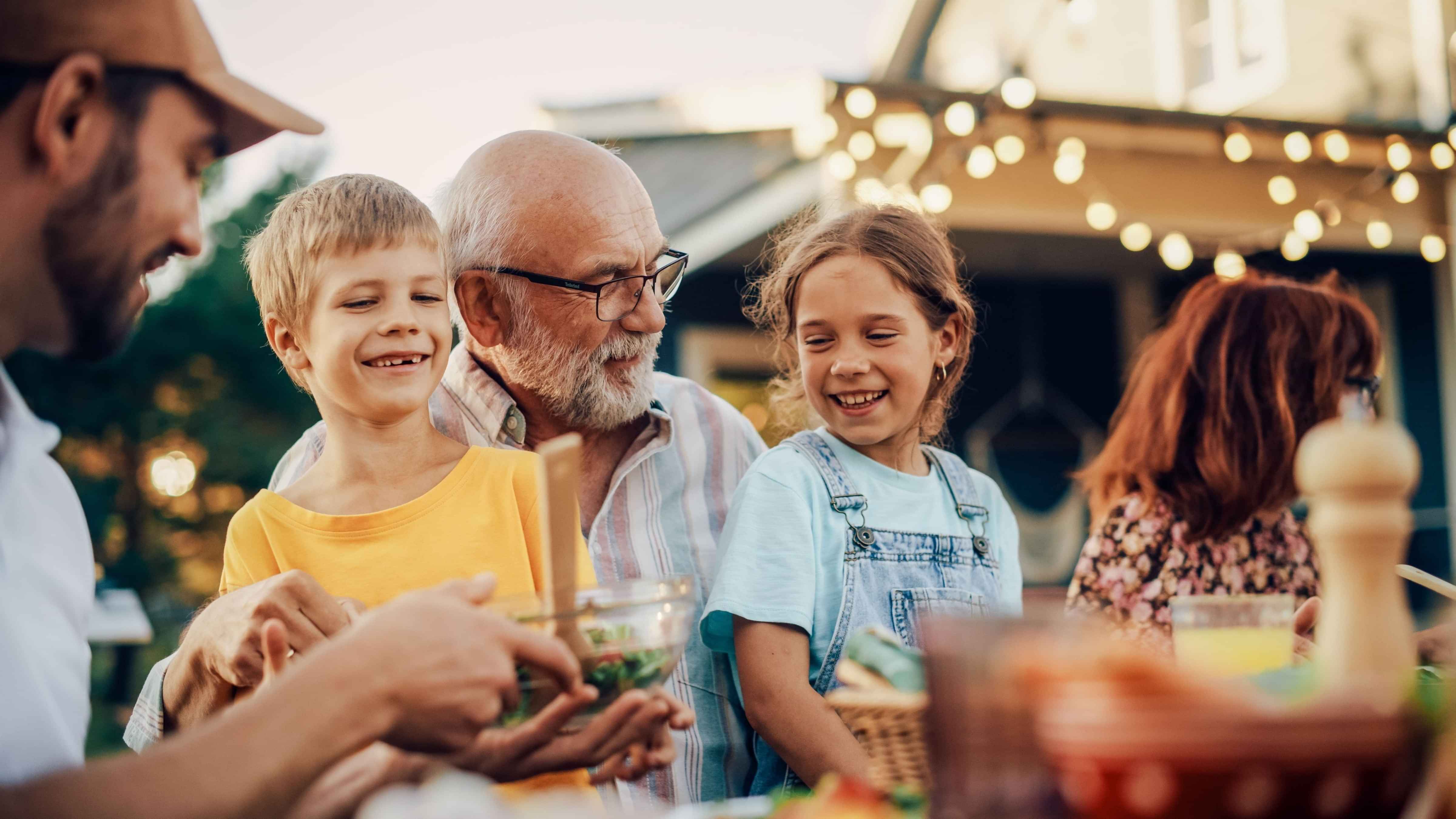 Grandad with grandson and daughter at an outside family dinner