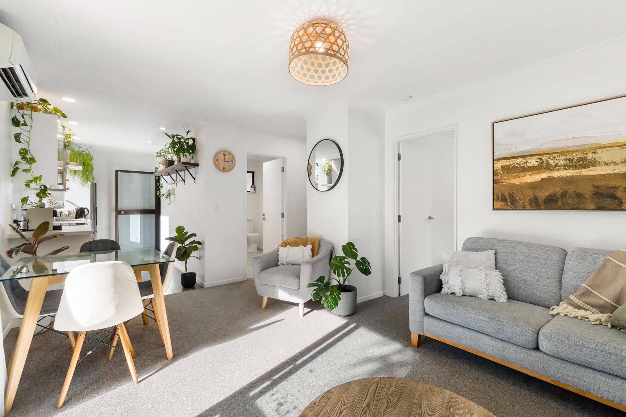 A modern and bright living area with table, chairs, and couch at one of Cambric's AirBnb properties