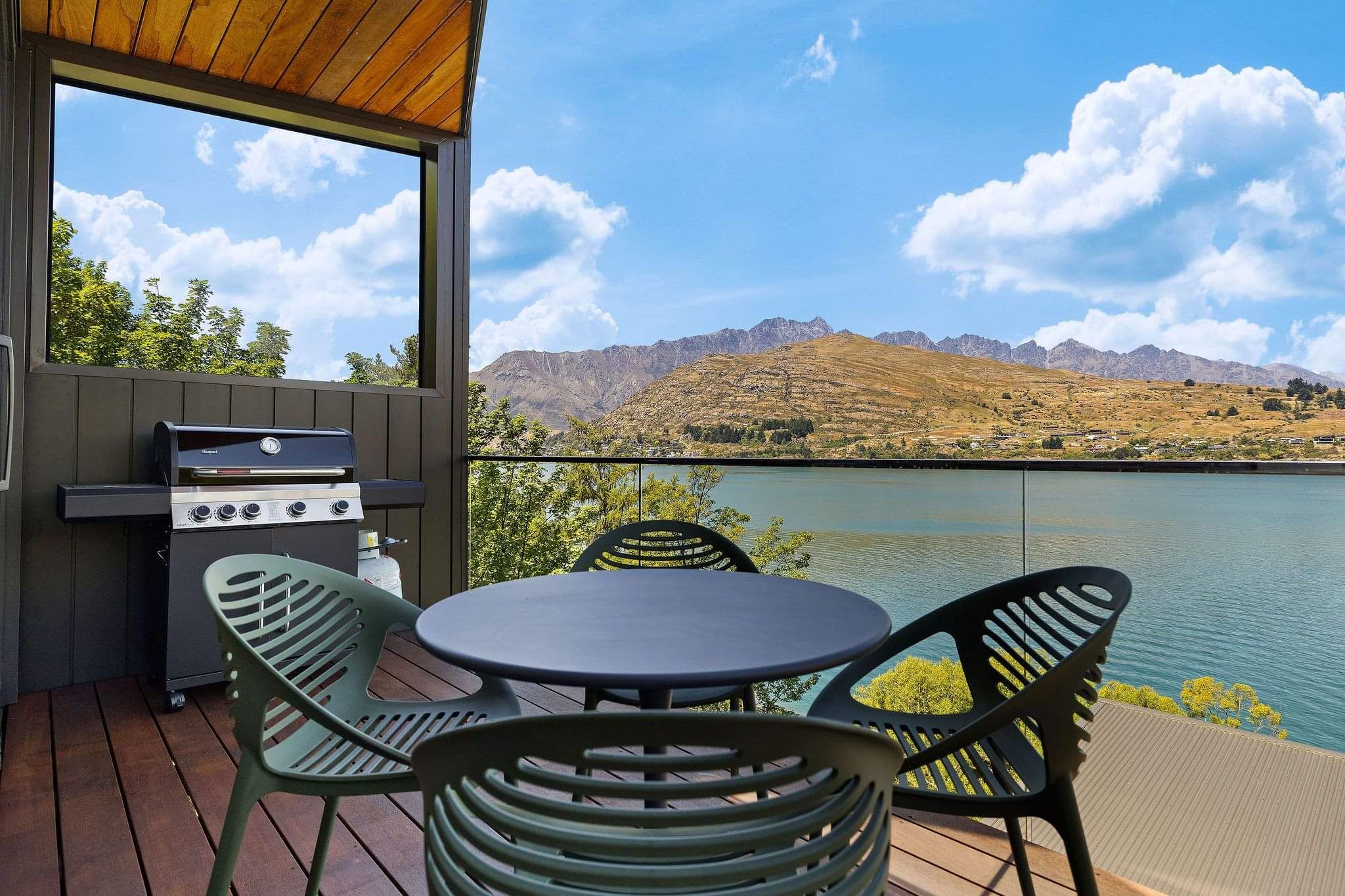 An outdoor dining space with view of Lake Wakatipu at one of Cambric's AirBnb properties
