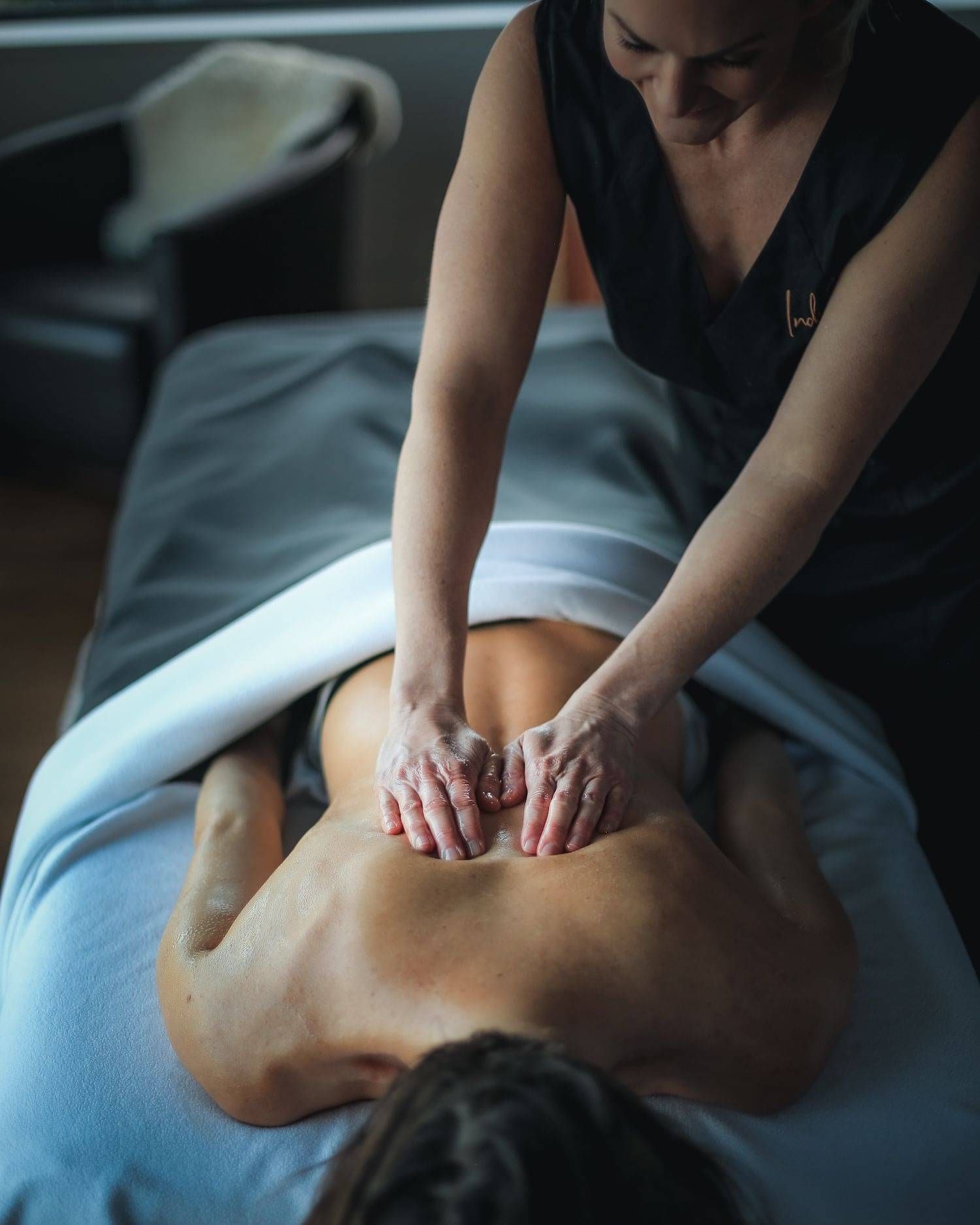 An Indulge team member massaging a clients back.