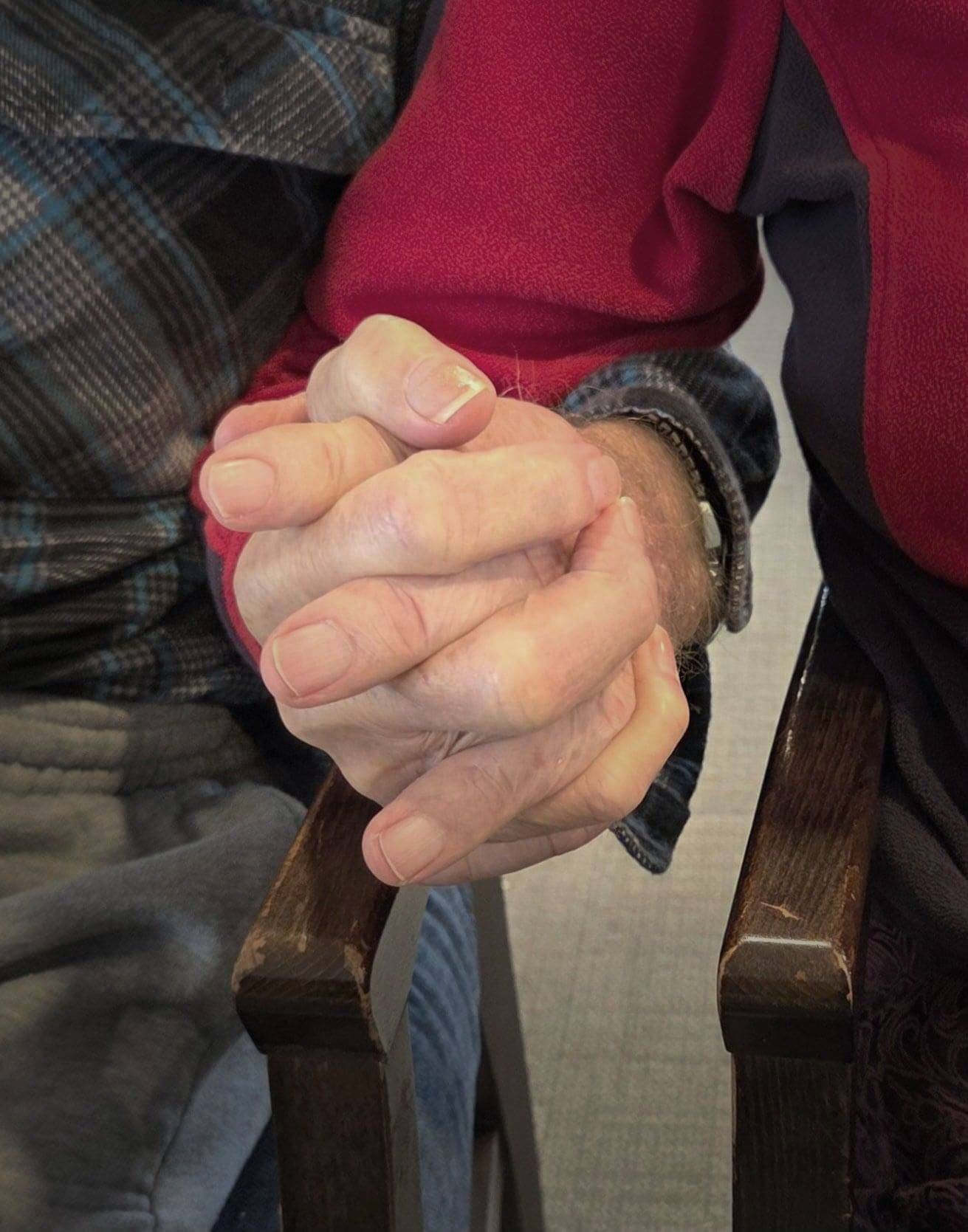 Elderly couple holding hands