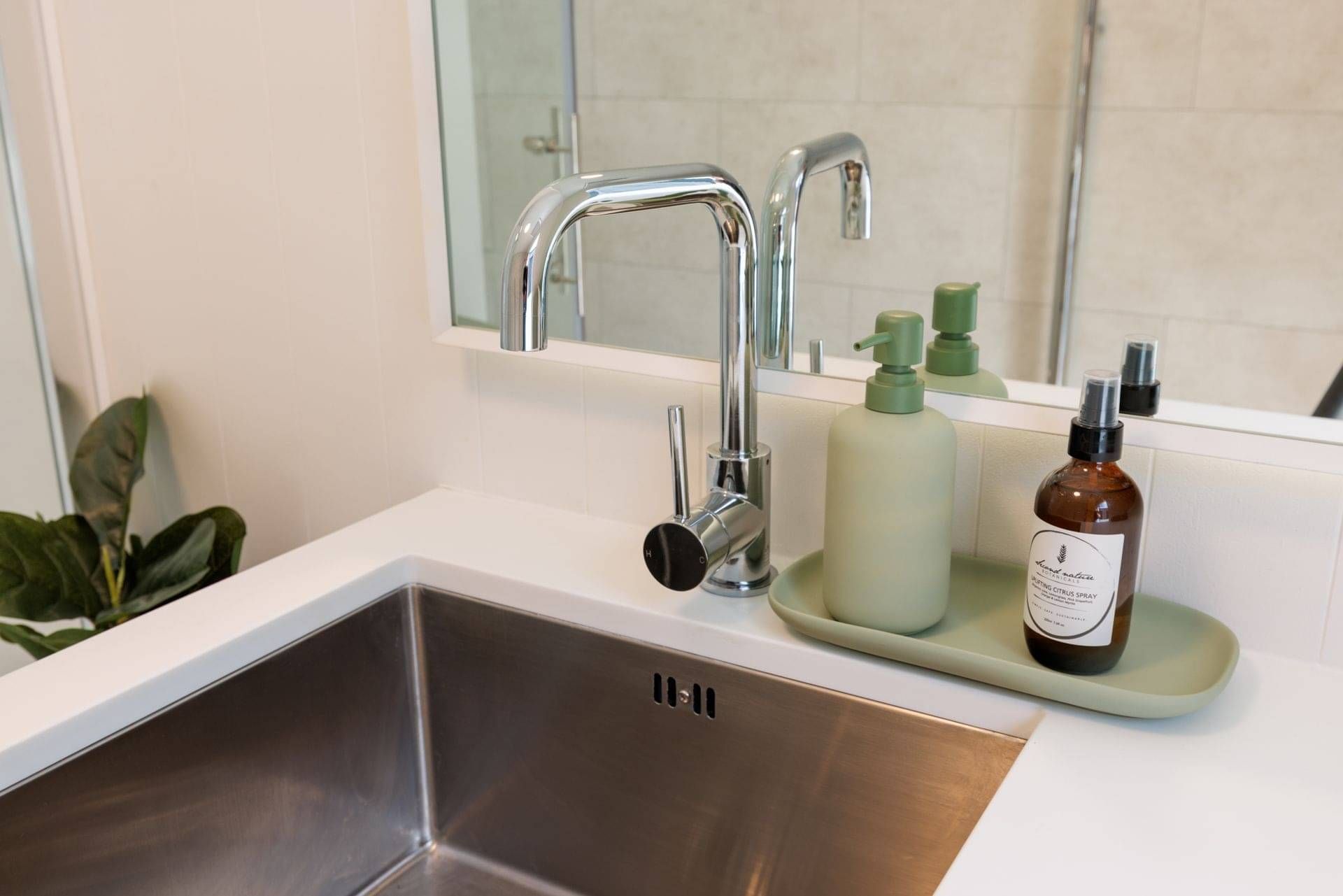 A stainless steel sink with a chrome mixer tap.