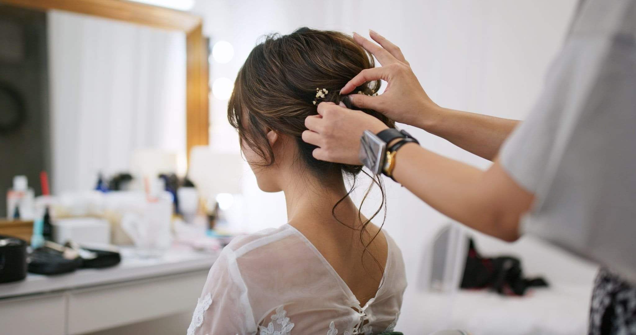 Hair stylist styling clients hair in up-do
