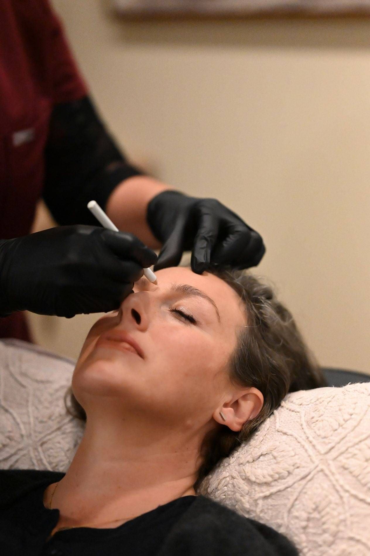 Photo of Kylie Dillon preparing a client for Cosmetic Treatment