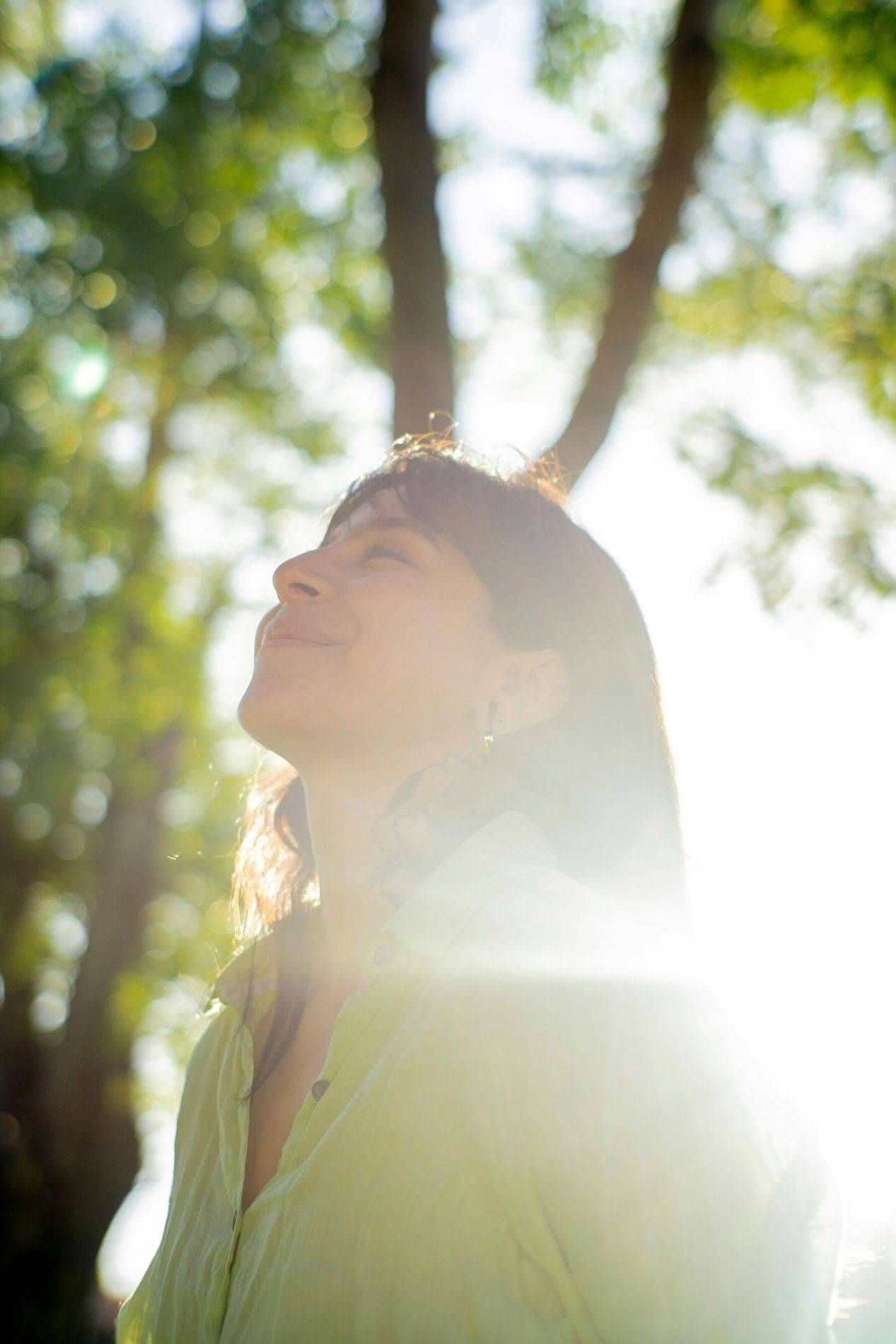 Photo of a woman enjoying sunlight on her face