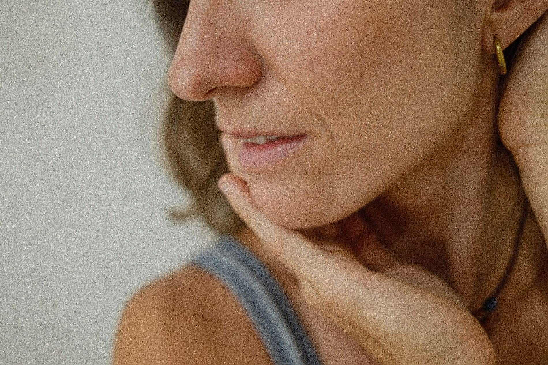 Photo of a woman feeling her face