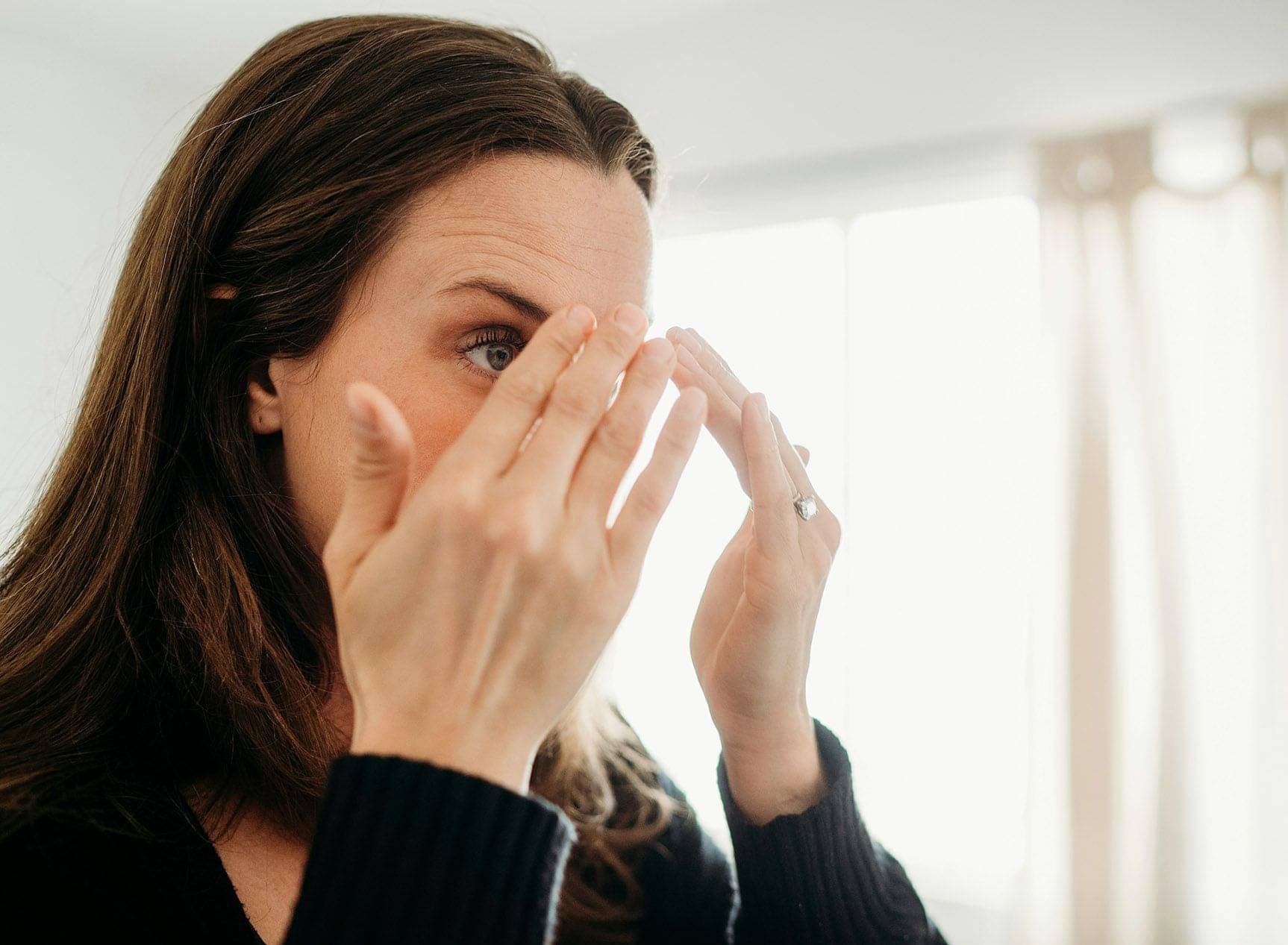 Photo of a woman applying face cream