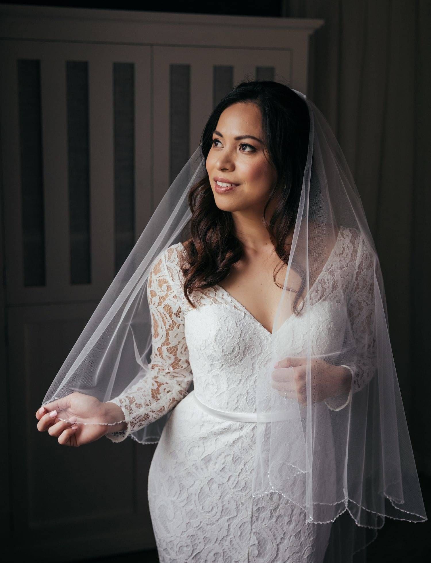 A bride in dress and veil with hair styled by Georgie.