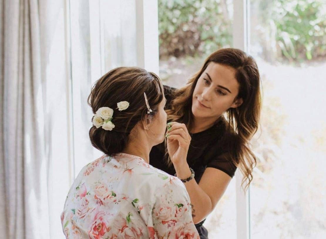 Georgie putting final makeup touches on a client.