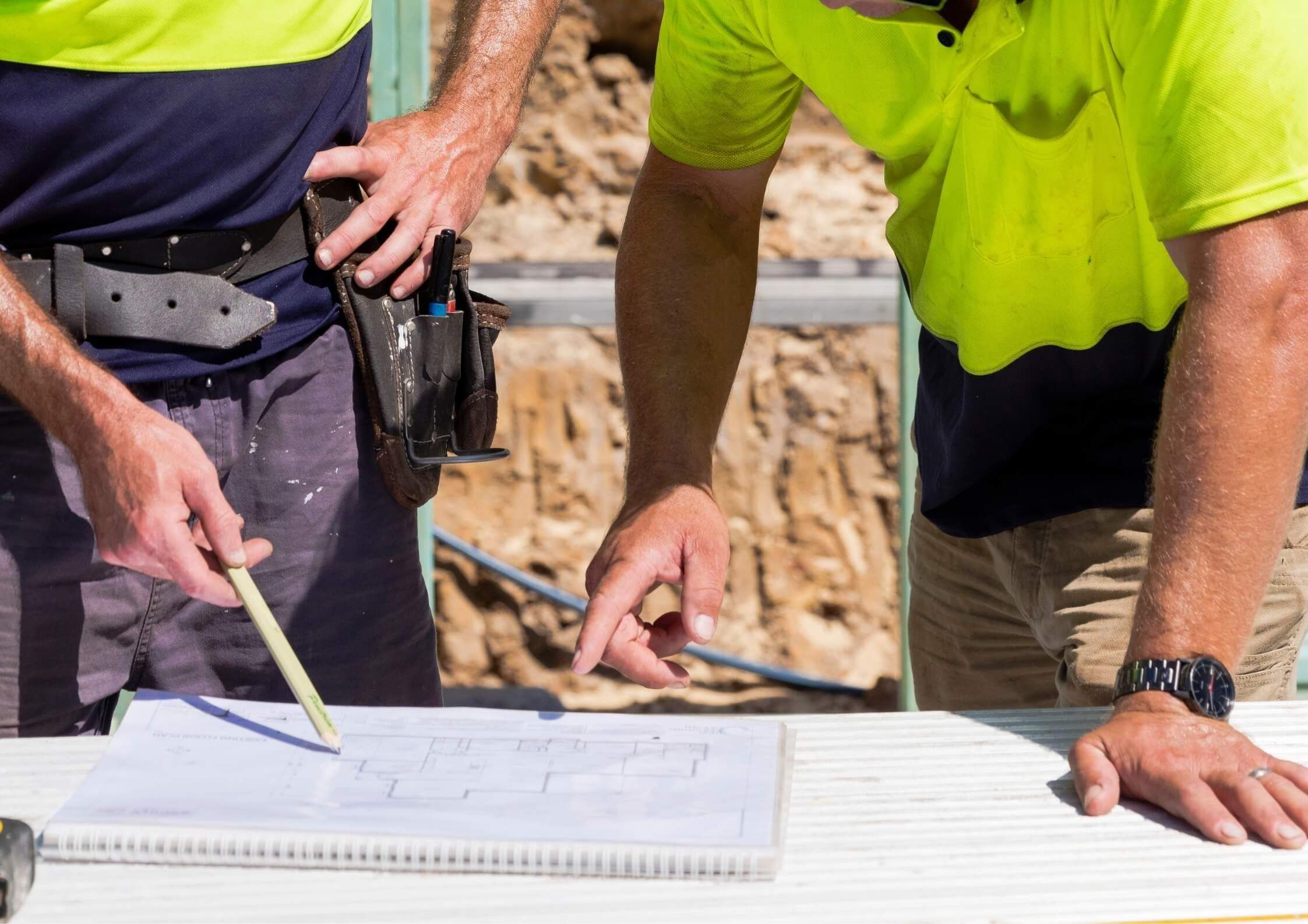 quality craftsmanship, two builders checking over plans for an insurance reinstatement project in the Bay of Plenty