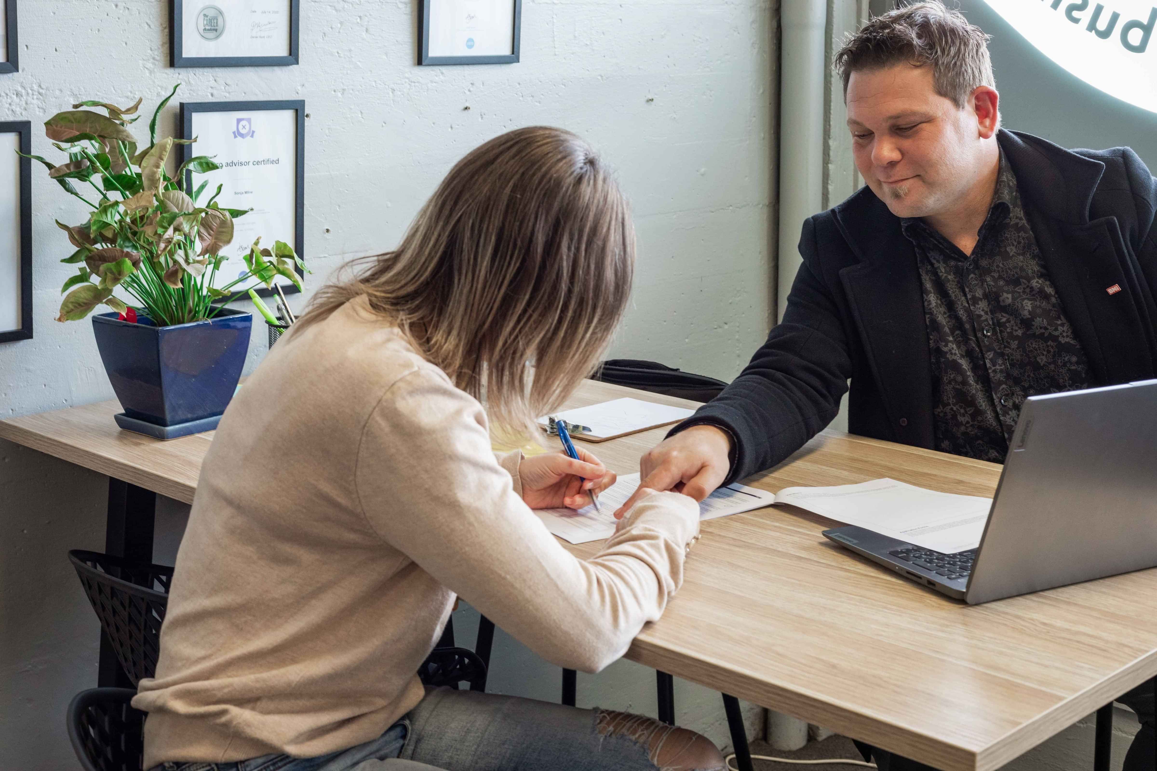 Business Owner signing paperwork with an Insurance Adviser