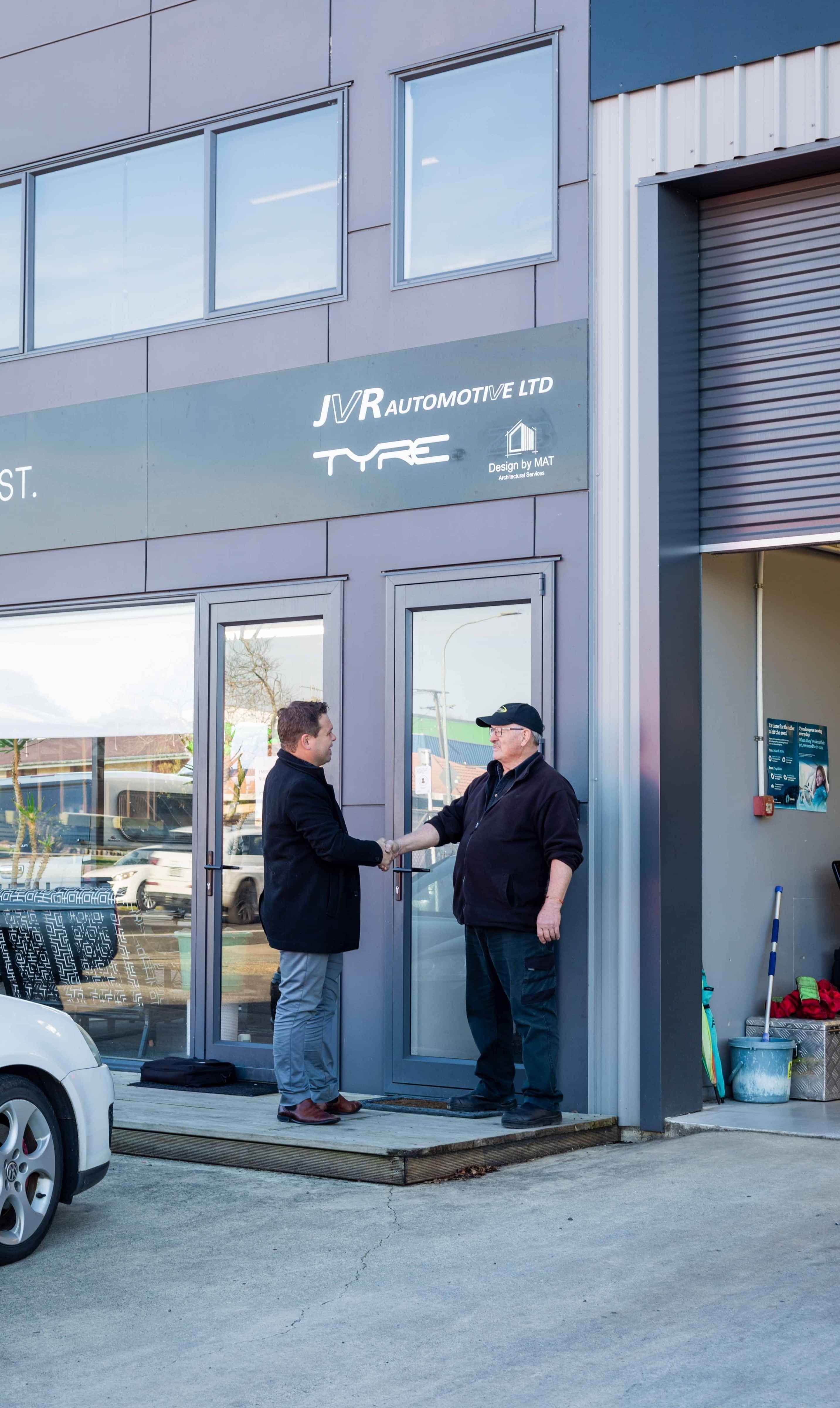 Mechanic and Insurance Adviser shaking hands outside the workshop