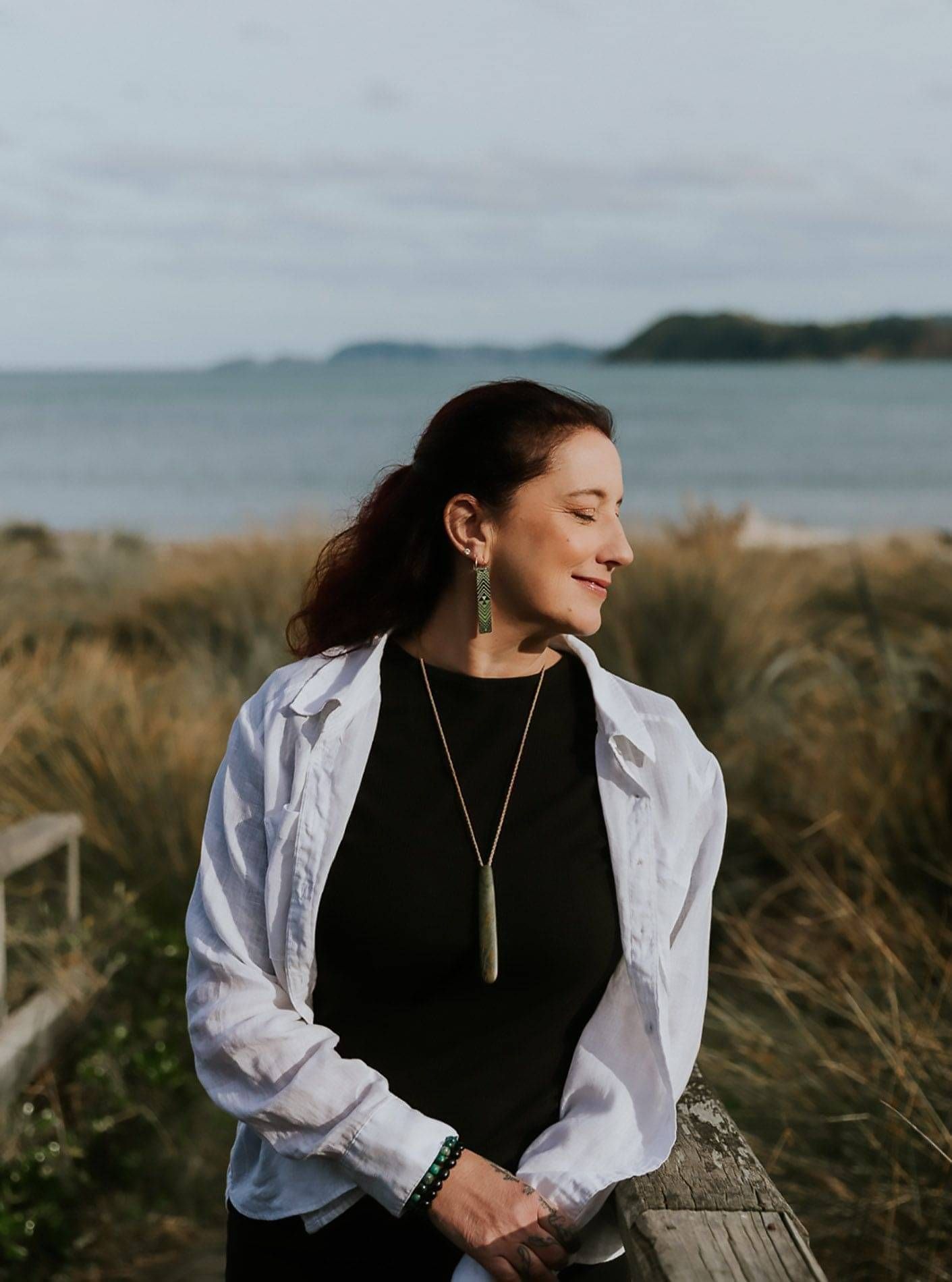 Photo of Lorraine Sinclair sitting at the beach in Wellington