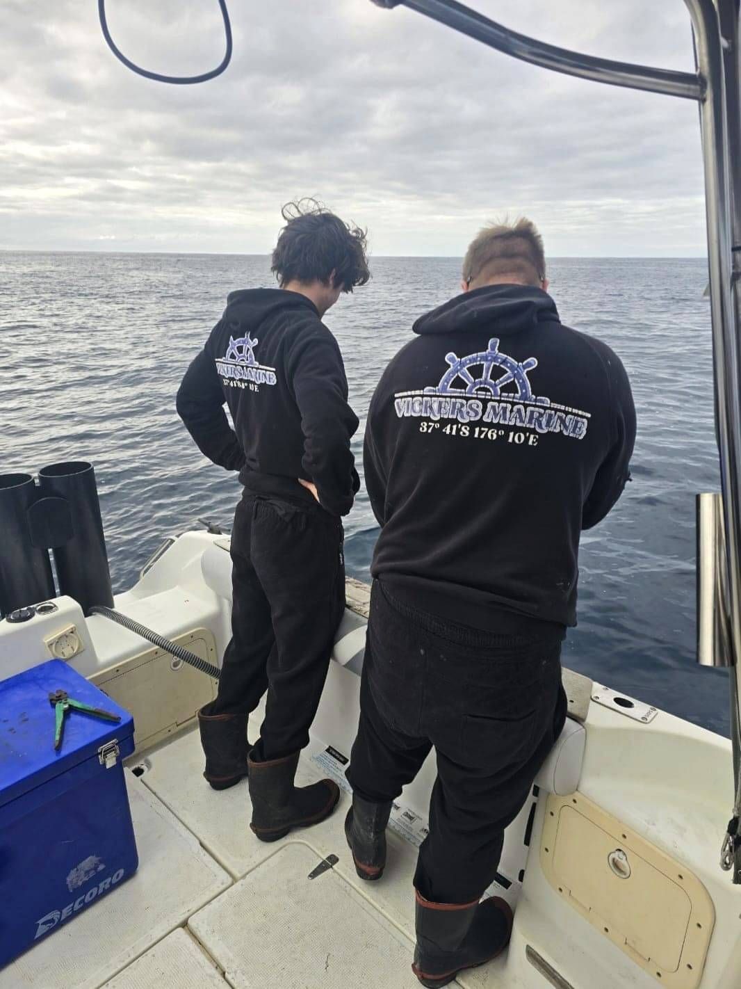 Two guys from Vickers Marine wearing Vickers Marine hoodies out on the boat