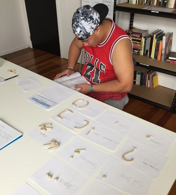 Maori man sitting at table reading