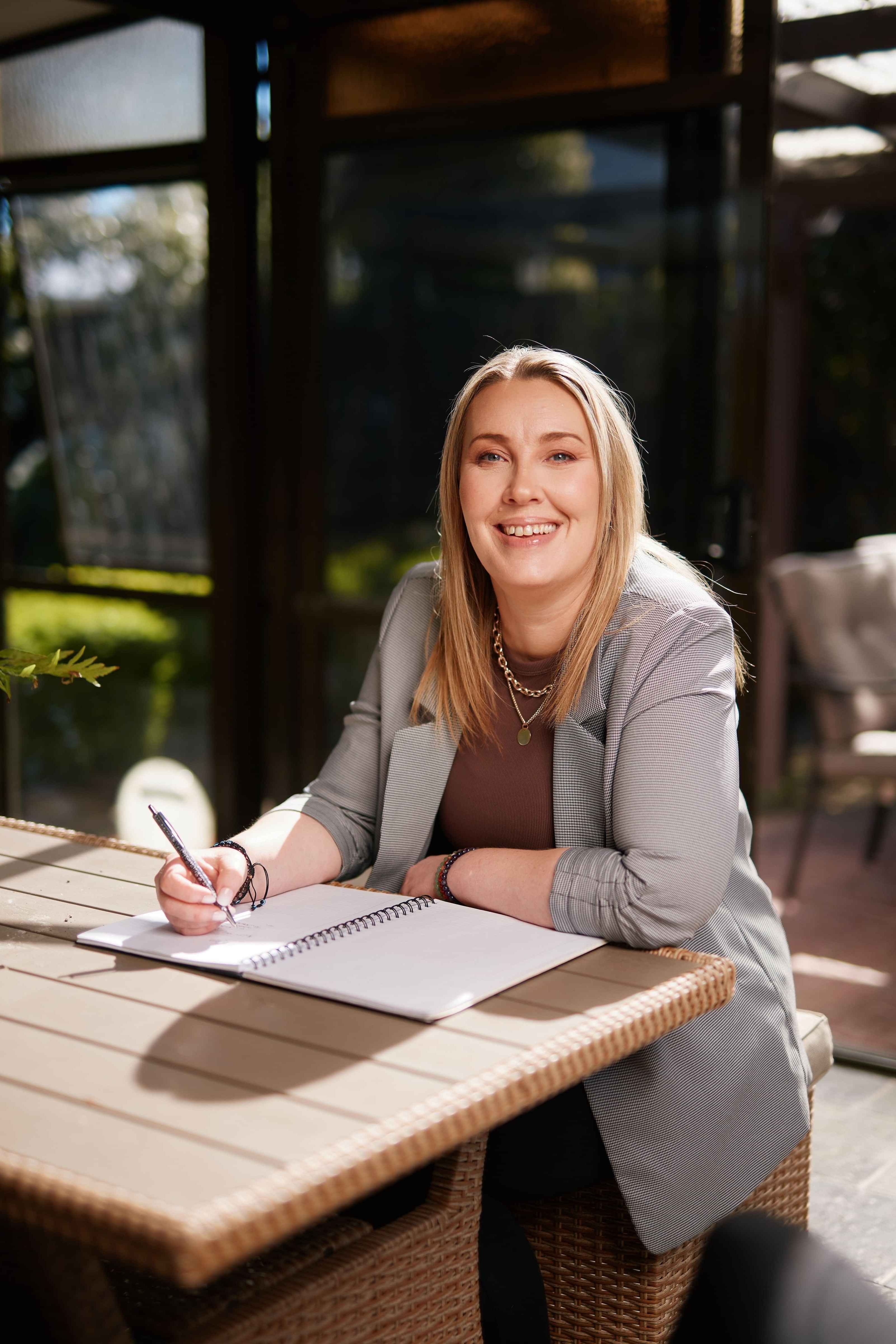 Amber smiling with a notebook