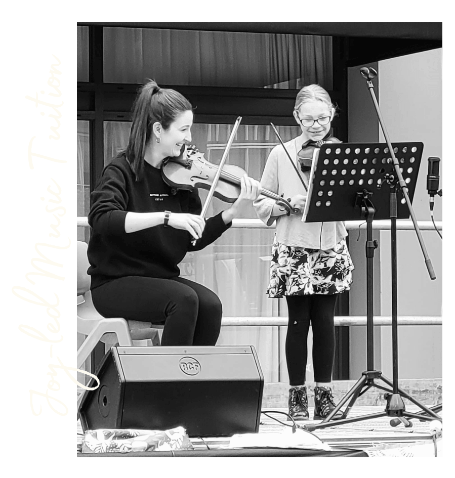 A picture of Erica playing alongside one of her students.