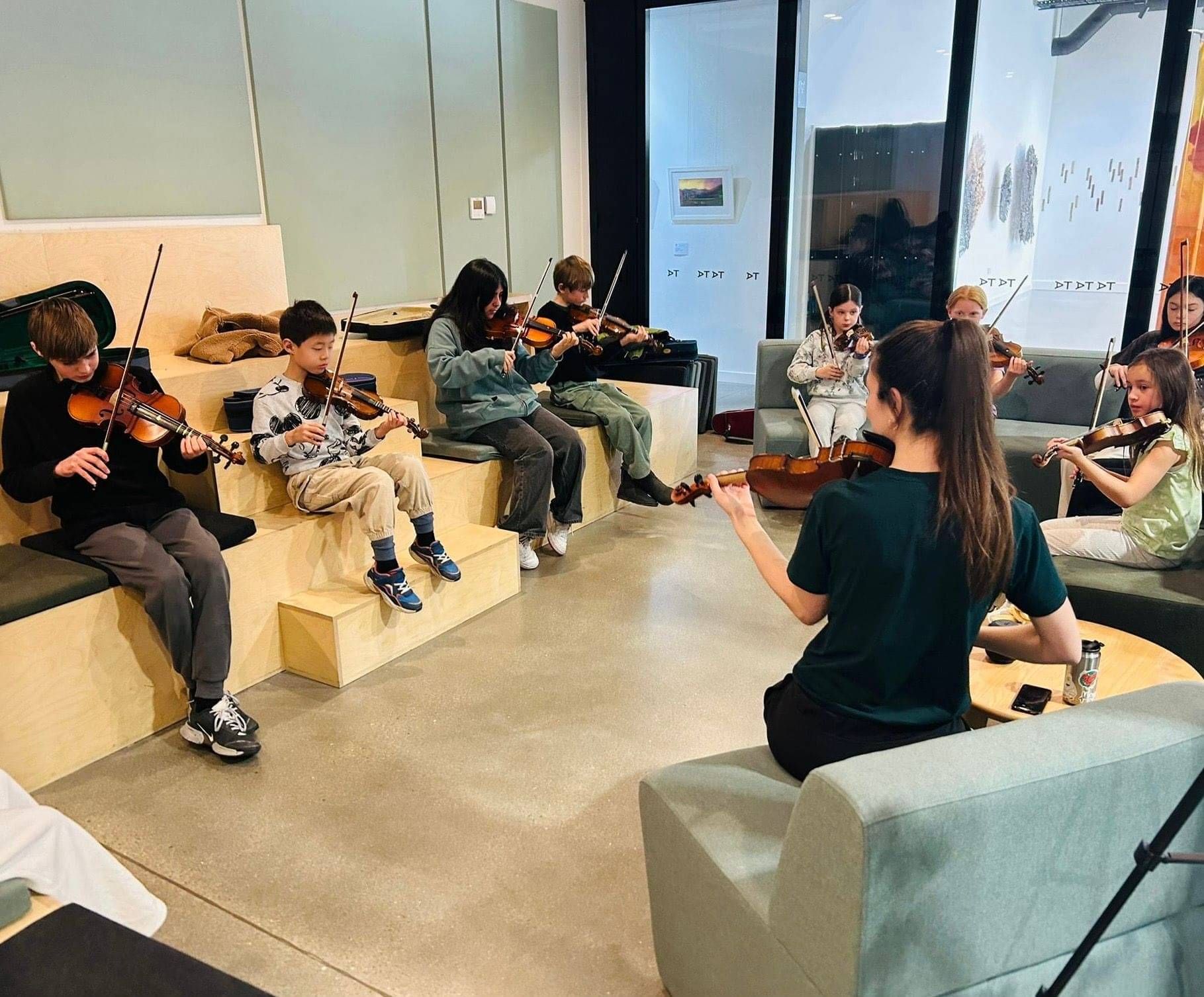 Erica playing violin with her students.