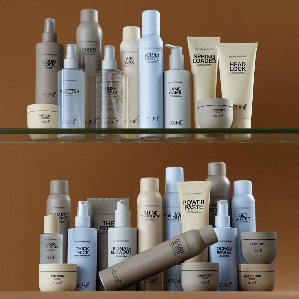 A collection of Keune hair styling products on glass shelving.