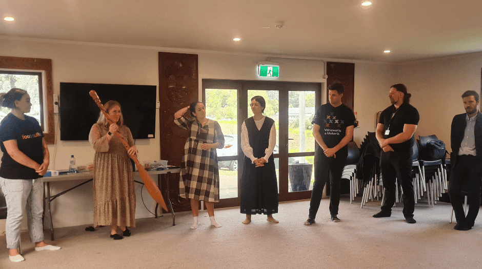 Group of participants standing in a workshop facilitated by AraHina for Foodstuffs’ Te Uru Kahikatea Māori Network.