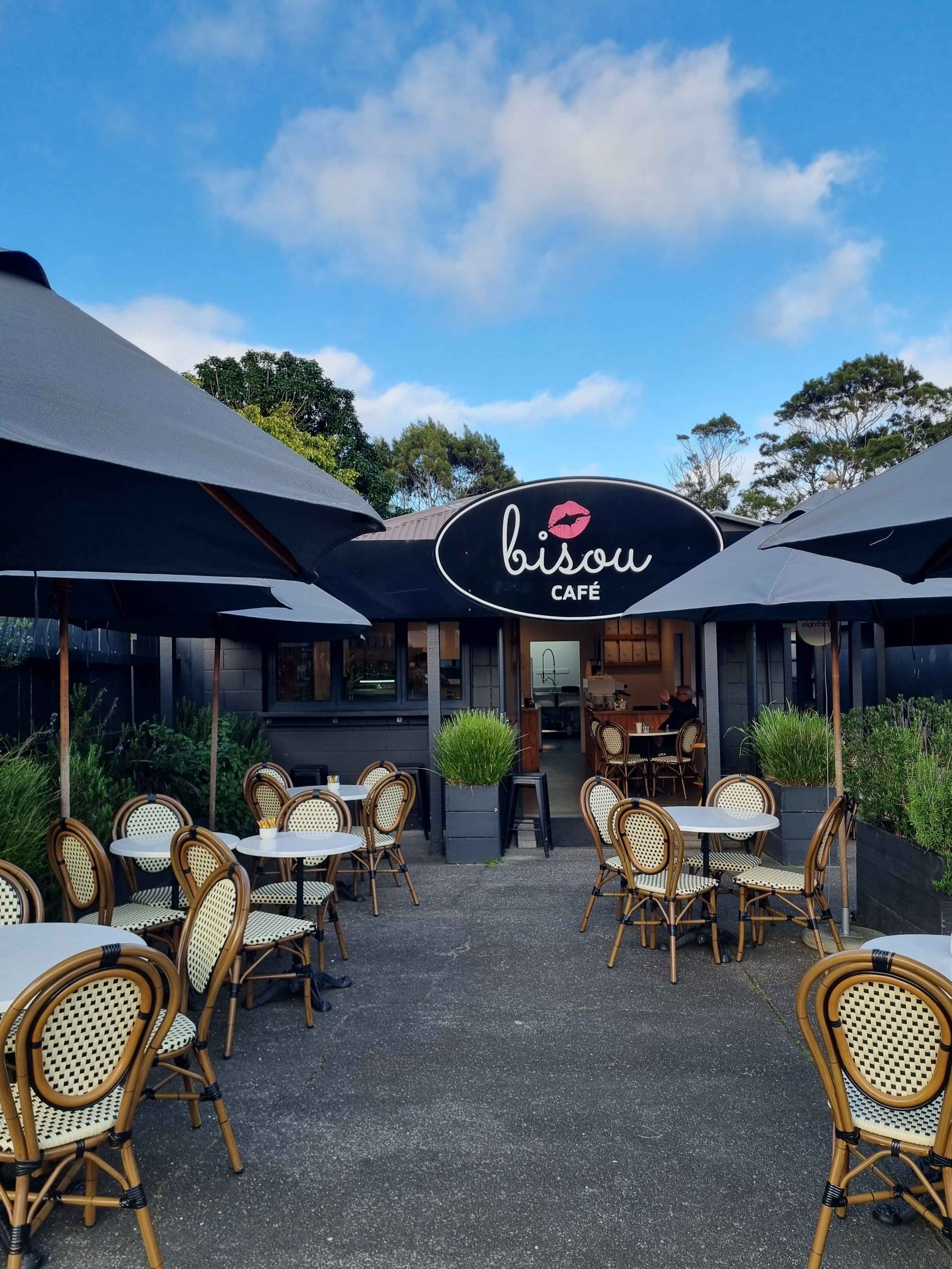 The front of our little Bisou cafe, set up for the day. tables outside and umbrellas are out.