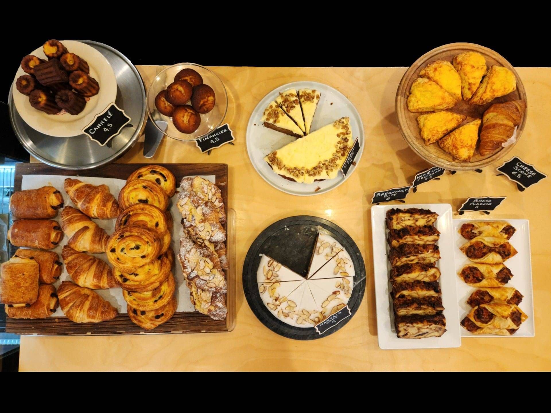 over top Photo of Pastries, cakes and sweet treats. at the bottom the world famous cheese scone is in full view.