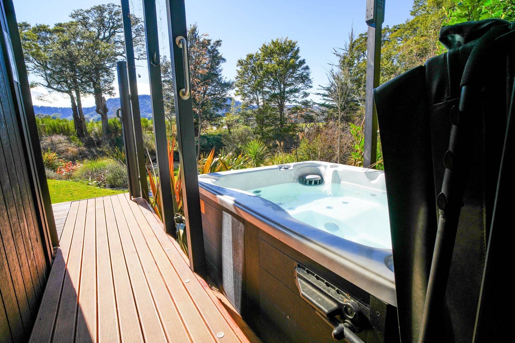 Private hot tub at Rua Awa with views of native gardens, rivers and Mt Ruapehu in a tranquil natural setting.