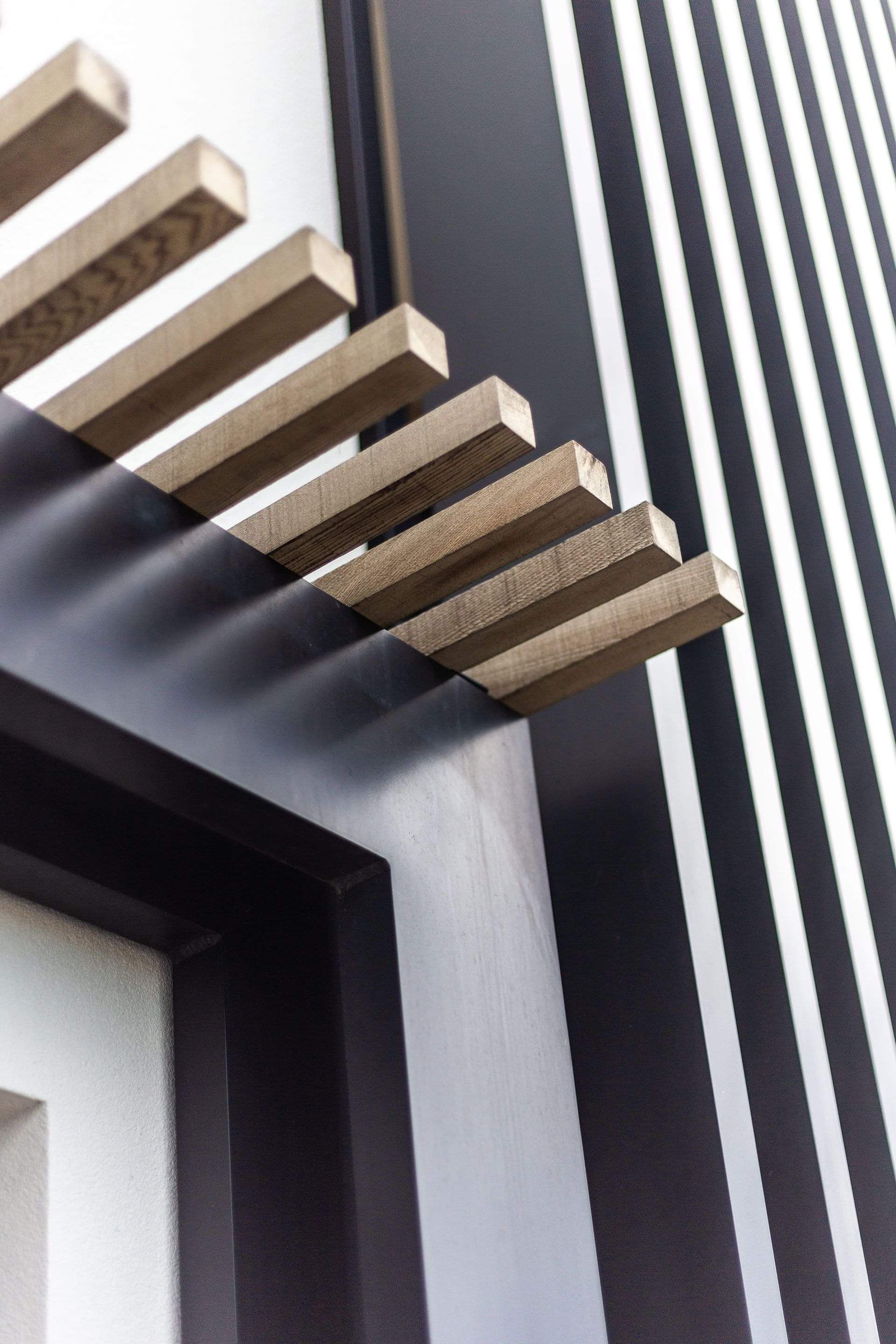 The image shows a close-up of the external cladding on a completed Papamoa builder's renovation, featuring metal beams and timber battens. 