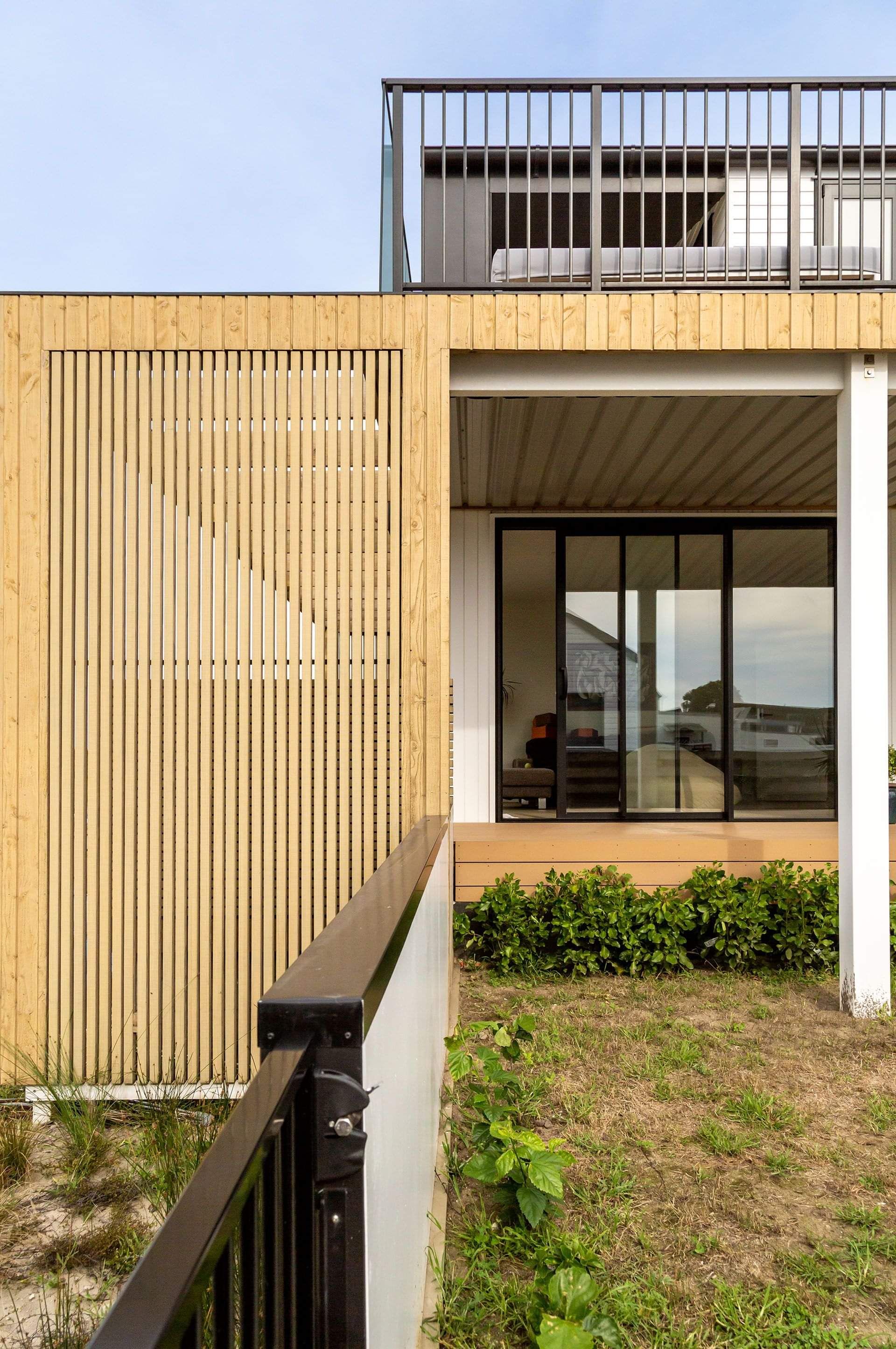 A close up image of a completed home builder's renovation in Papamoa with timber fascia, new joinery, deck, and ballustrade. 