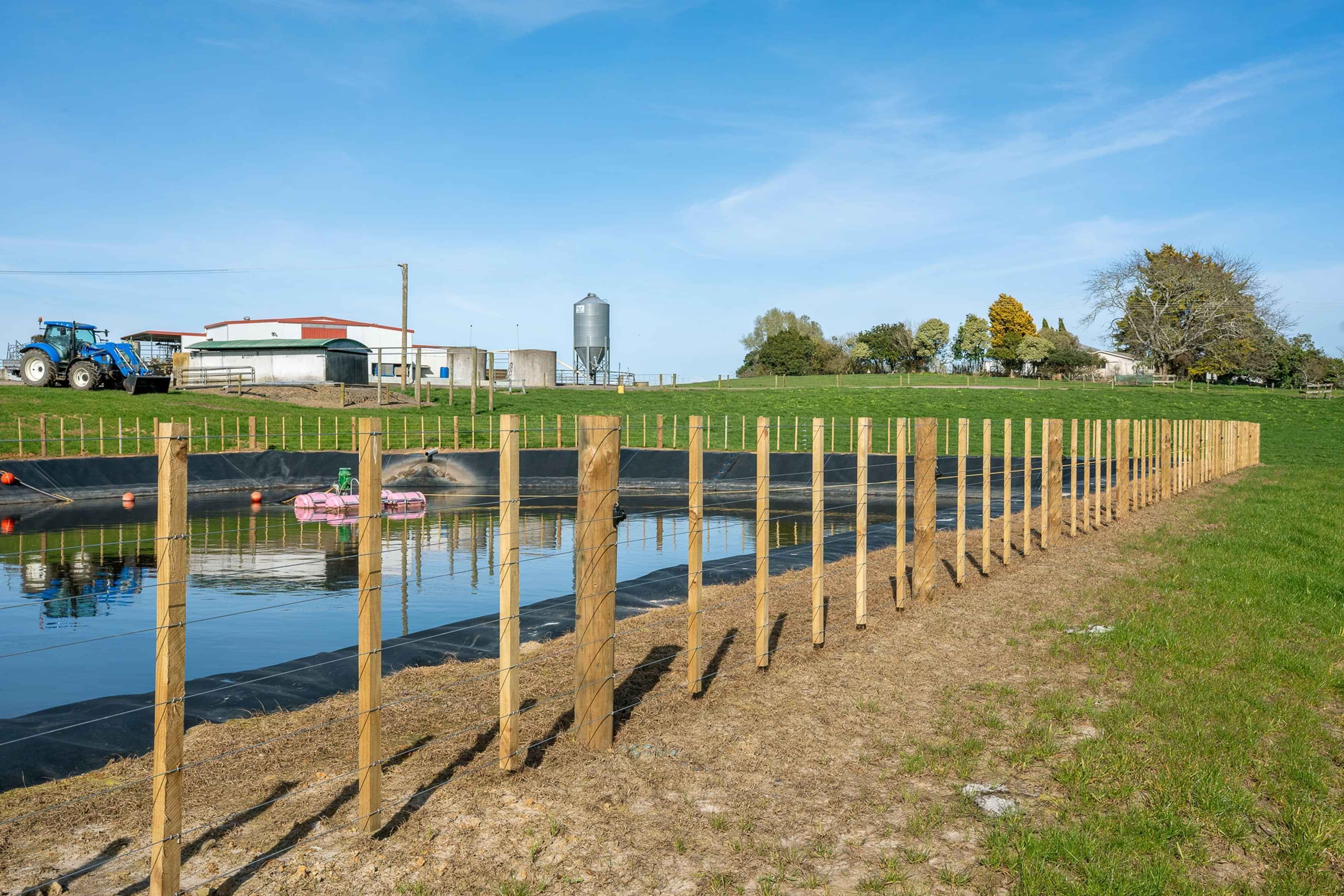 Image of wire and batten fencing surrounding an effluent pond on a farm. Fencing by Habraken Fencing, Waikato.
