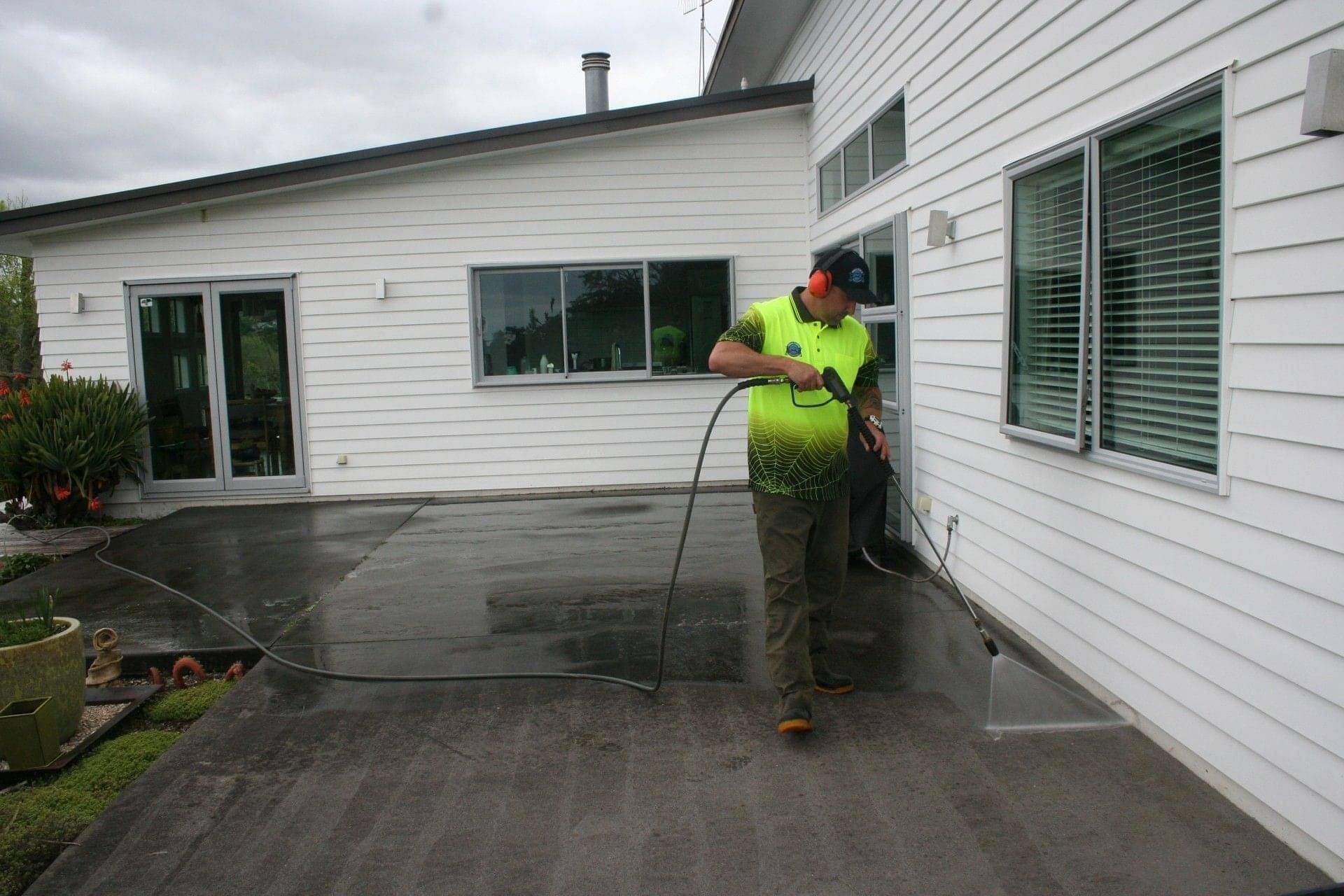 Photo of Aqua Force team member pressure washing concrete patio
