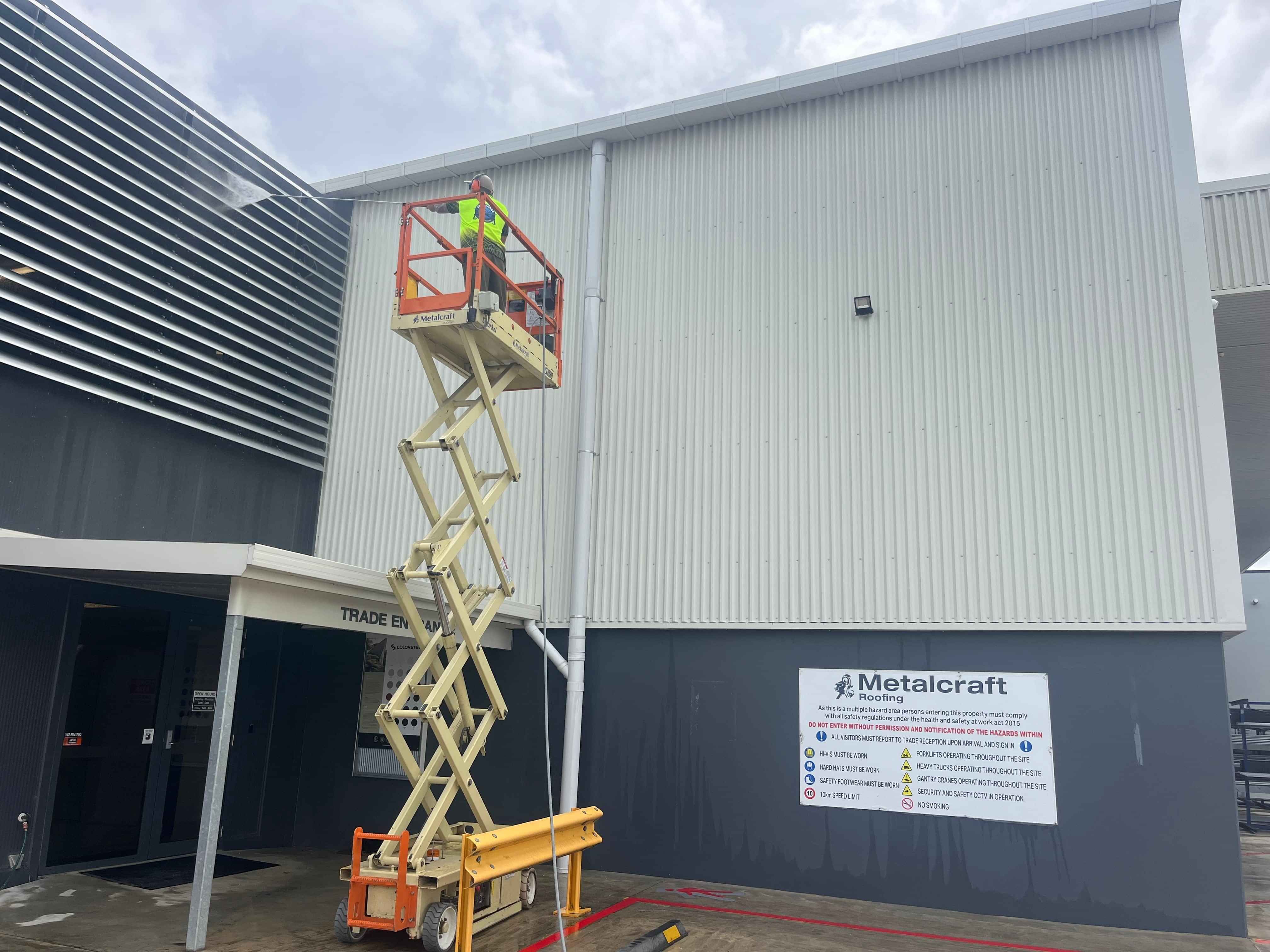 Photo of Aqua Force waterblasting the walls of a local Hamilton business